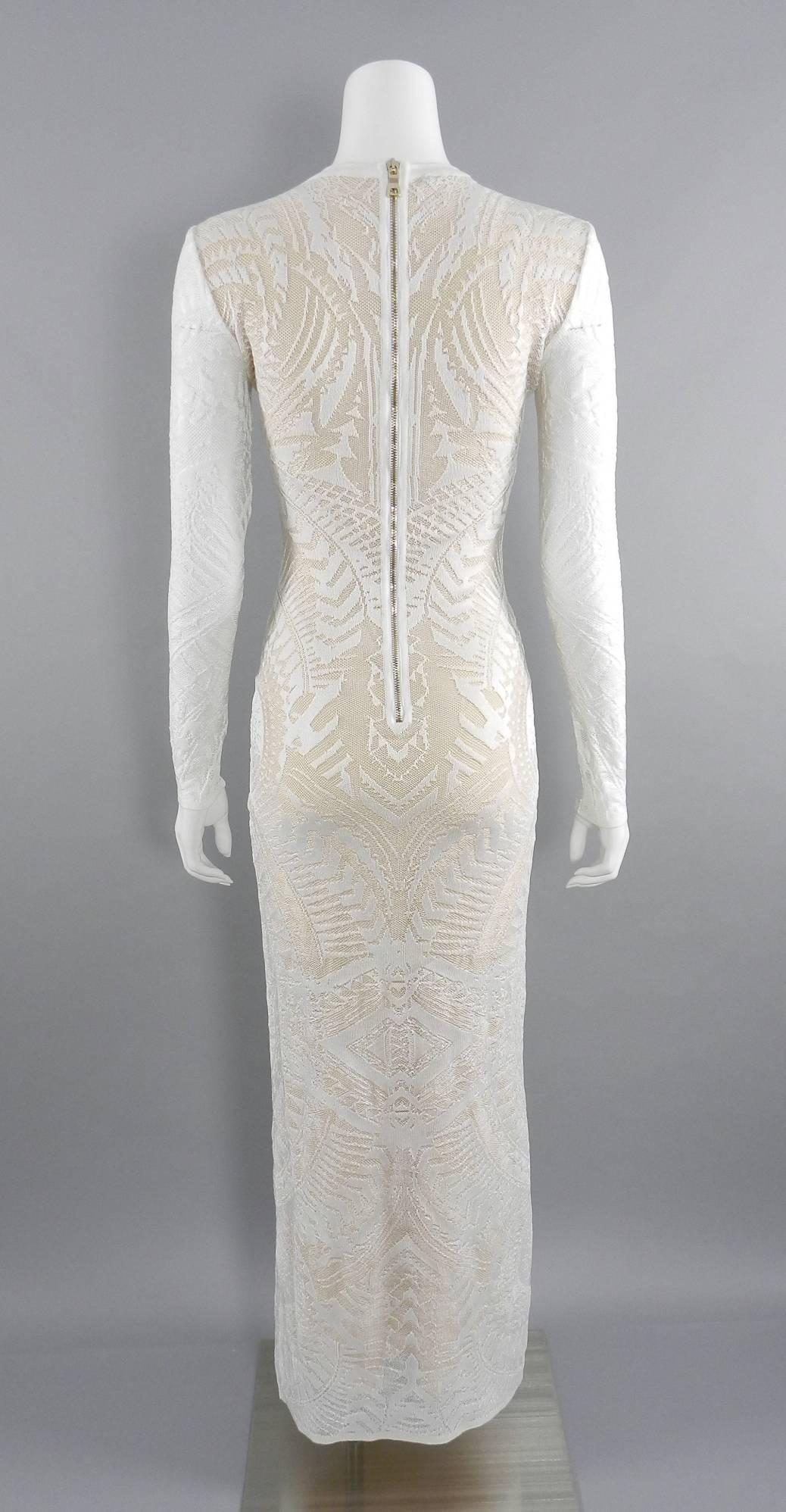 Balmain long white lace stretch dress with nude lining.  Centre back gold metal zipper and long sheer sleeves.  Tagged size FR 38 (USA 6). Stretchy knit tube dress so flexible but recommended measurements are as follows:

Bust:  32