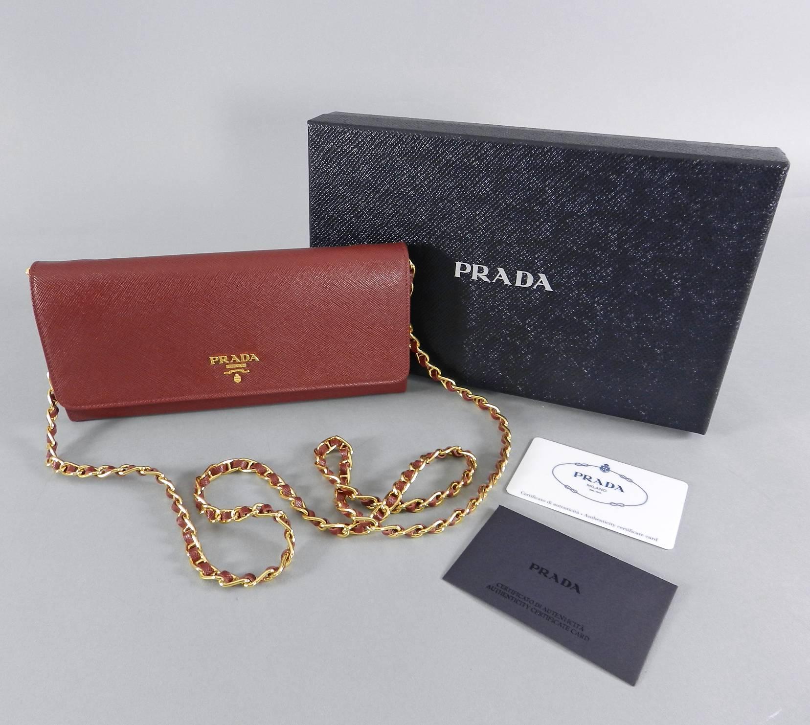 Prada Cerise Saffiano Leather Wallet on a Chain.  Gold metal hardware.  Includes authenticity card (purchases at NYC Lafayette store) and box. New in box.  Measures 8.25 x 4 x 1