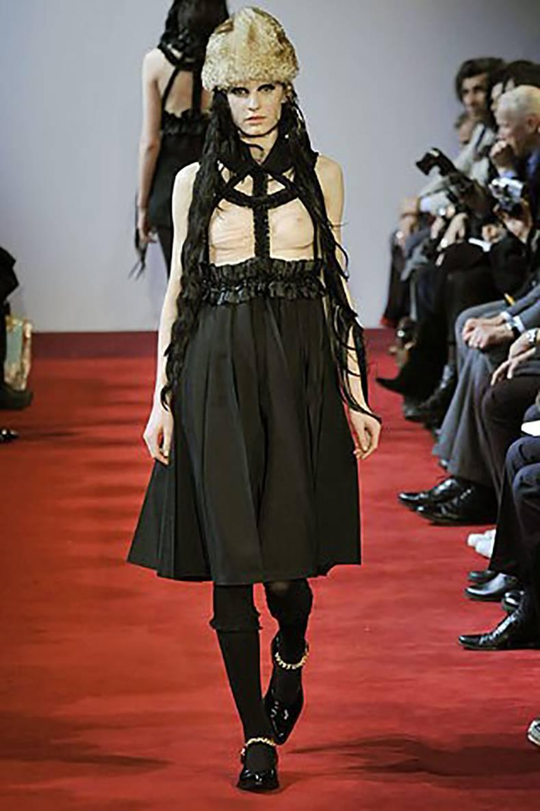 Comme des Garcons Fall 2008 Runway Black ribbon Suspender Dress.  Open ribbon harness design at top with pleated midi wool skirt. Has no zippers or fasteners and goes on over the head and shoulders with stretch elastic waist and neckline. Marked