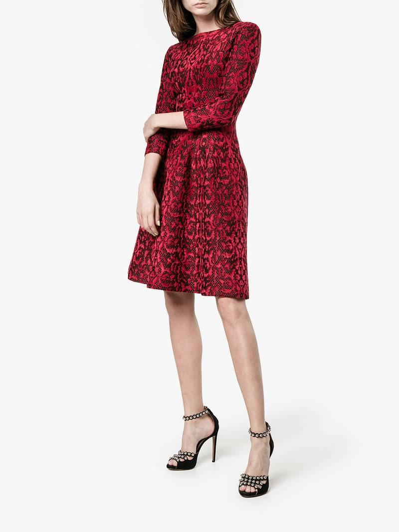 ALAIA Fall 2016 Red and black flocked Lace Overlay cocktail dress.  Stretch knit material with long sleeves, fitted body, and slight a-line skirt.   Catalogue photo shows a design with gathered waist but this garment is smooth against stomach.