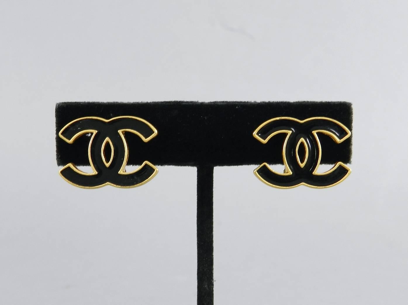 Chanel 02A CC logo clip on earrings. Matte brushed goldtone metal with black enamel.  Excellent pre-owned.  Measures about 0.75" x 5/8".

We ship worldwide.