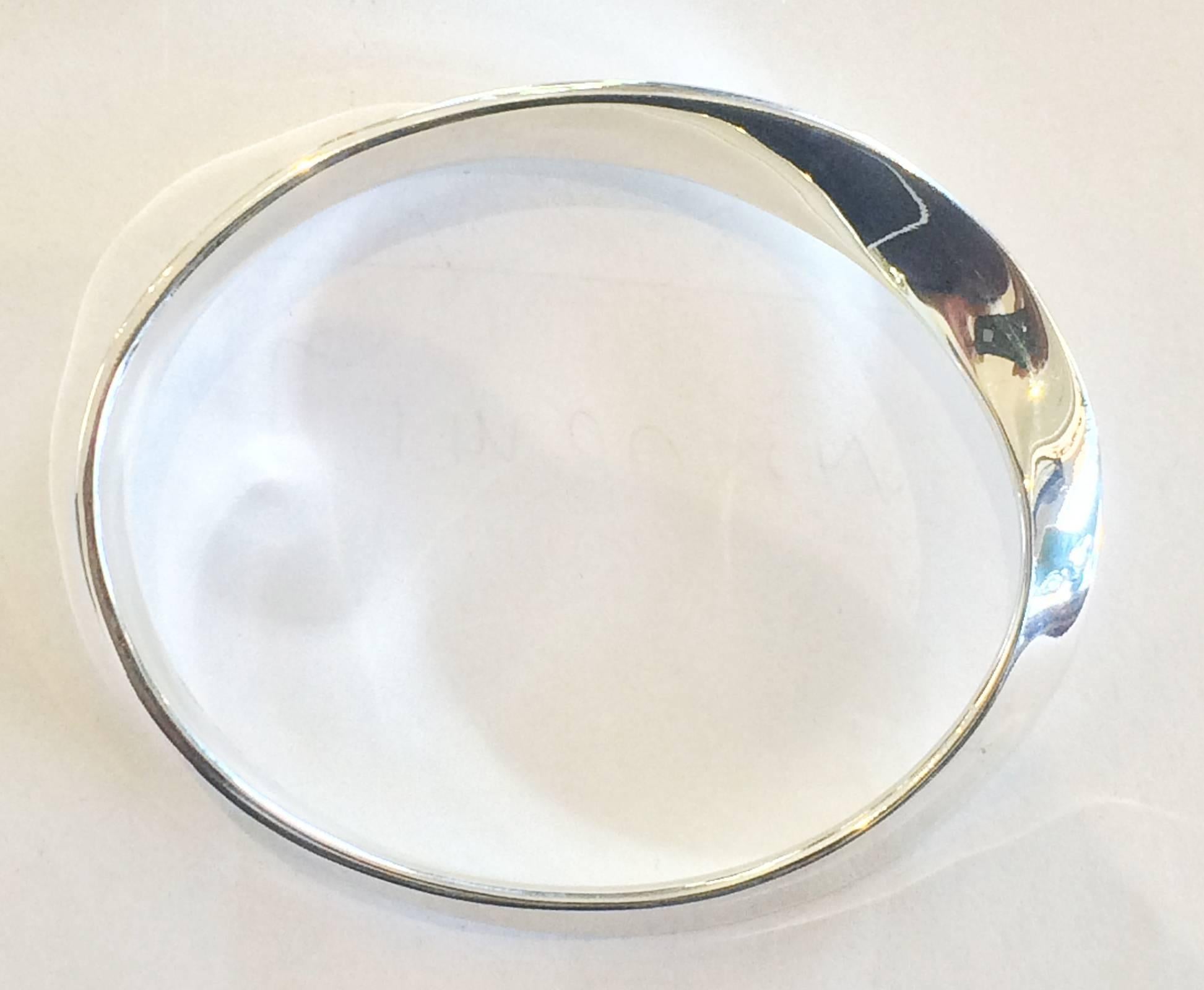 A Georg Jensen Silver MOBIUS bangle designed by Vivianna Torun Bülow-Hübe. In math, a MÖBIUS is a shape with one surface and one edge. Launched in 1968, MÖBIUS is a great example of Georg Jensen design from the mid to late 20th century  This is