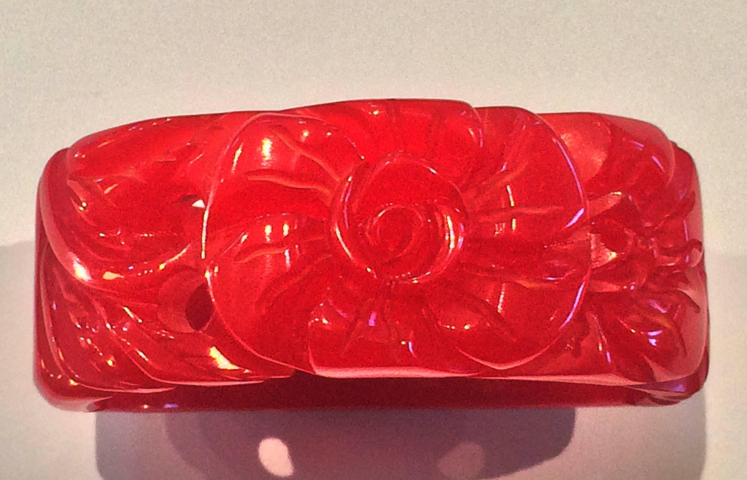 A fabulous almost translucent Art Deco hinged bracelet or clamper. Deeply Carved Cherry Red Bakelite of a rose on the front.. Immaculate condition with hinge clasp in perfect working order and no damage or repirs. Dimensions are approx.. : Interior