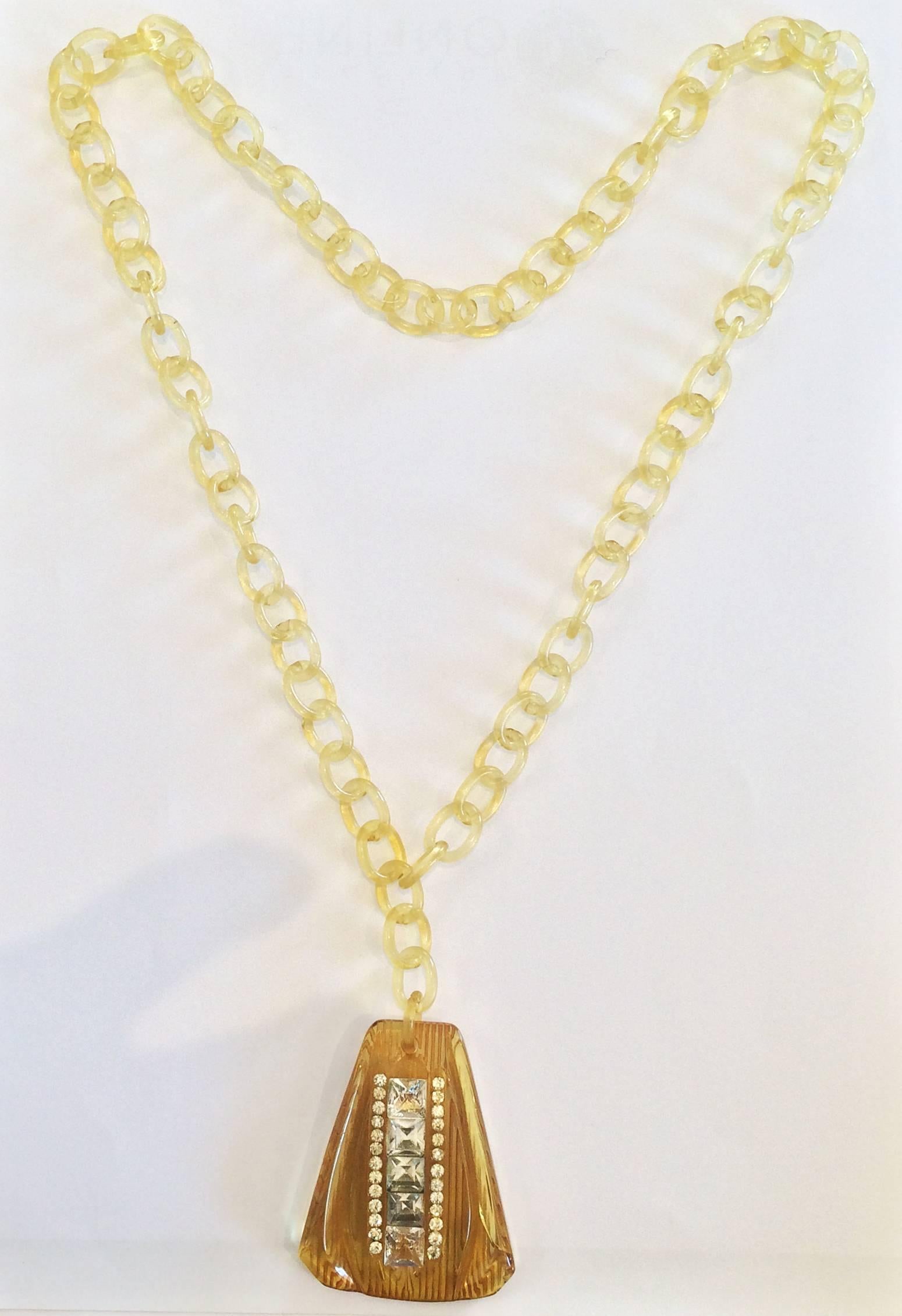 Art Deco necklace, with Applejuice Bakelite Pendant, carved and inset with Baguette rhinestones and including the full celluloid chain, all in perfect condition. Very rare to still have the chain intact with no breakage or losses. The pendant is