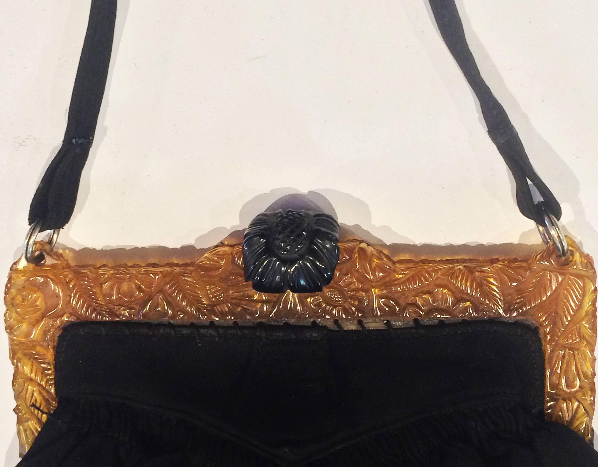 Art Deco, Rare black Suede Handbag, with carved Apple juice Bakelite Frame and Black Bakelite clasp, all finely and deep carved flowers and large Daisy to the black Bakelite. Chrome rings to handle and clasp mechanicals. Interior is lined in silk