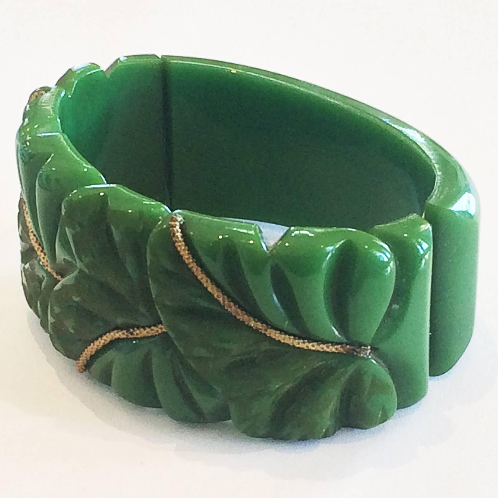 Art Deco Clamper Bangle heavily carved, mint green Bakelite in a leaf pattern, with patinated, gilt brass,  inset along each leaf centre. Original spring hinge in perfect working condition, with no damage or repairs at all to the bangle. One of the