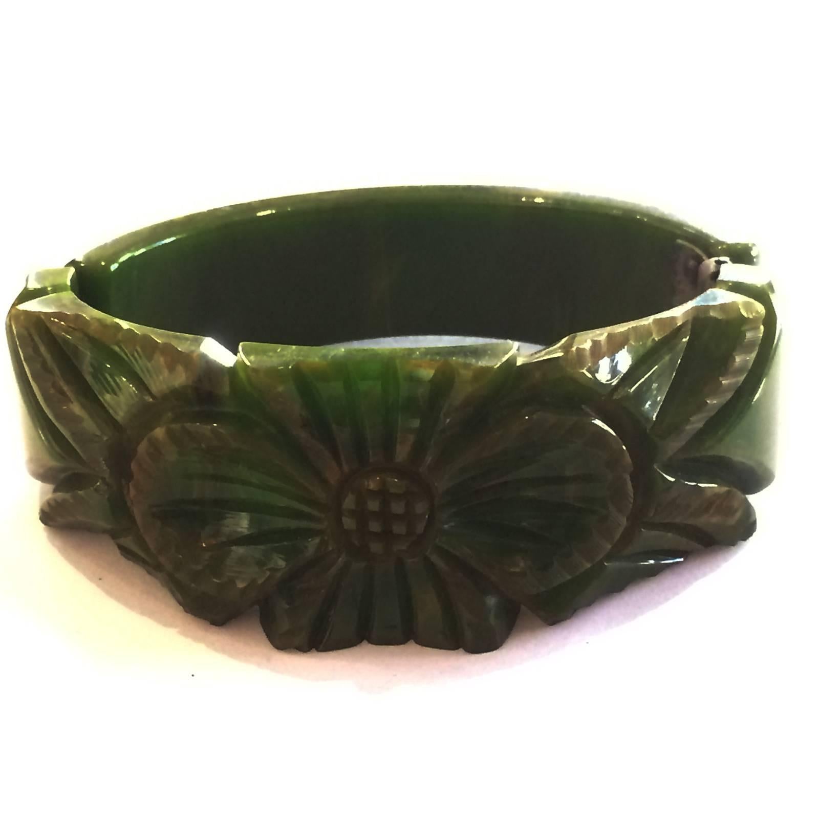Art Deco Clamper Bangle heavily carved, green with fine yellow vein Bakelite in a central Flower and leaf pattern. Original nickel plate spring hinge in perfect working condition, with no damage or repairs at all to the bangle. One of the best you