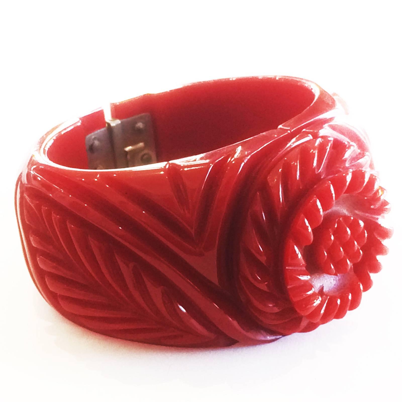 Art Deco, unusual, deeply Carved Bangle, in sold Lipstick Red Bakelite, in form of central Flower with leaves to left and right. The flower overlaps the joint of the other side, and some of the carving is up to 5mm deep. All in perfect condition,