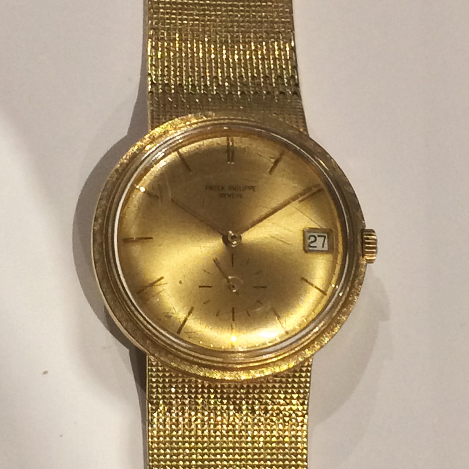 Automatic circular case with gold Dial, gold applied baton numerals, subsidiary Seconds dial and Date aperture. Case, Dial, and bracelet signed. Screw back with Octagon (10 side surround) screw access plate, with tapered mesh bracelet with textured