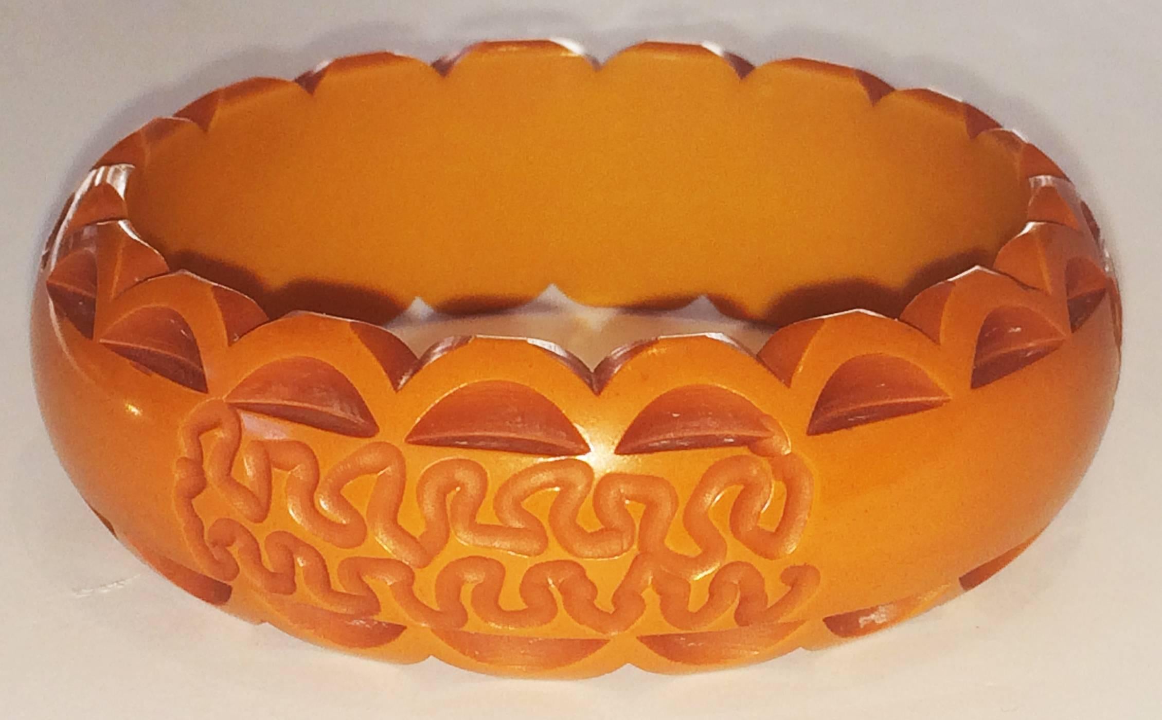 Art Deco Bangle, in deeply carved orange Bakelite. A great Deco colour and intricate carving on convex exterior surface. No damage, or repairs, all in perfect condition. Dimensions are approx..: Interior 66mm dia., exterior 80mm maximum, curved x