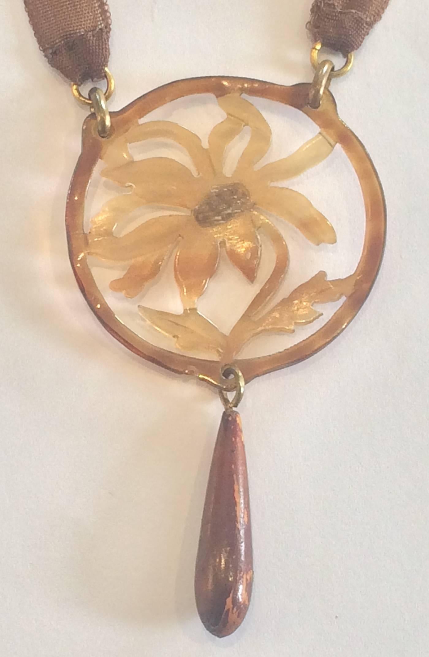 Art Nouveau Rare Necklace of Carved Horn, hand coloured and stained, decorated as a flower. Very fine detail, and the simple Tan silk neck band emphasises the fine pendant. Design by Georges Pierre, signed to rear.  Dimensions are approx..: Pendant