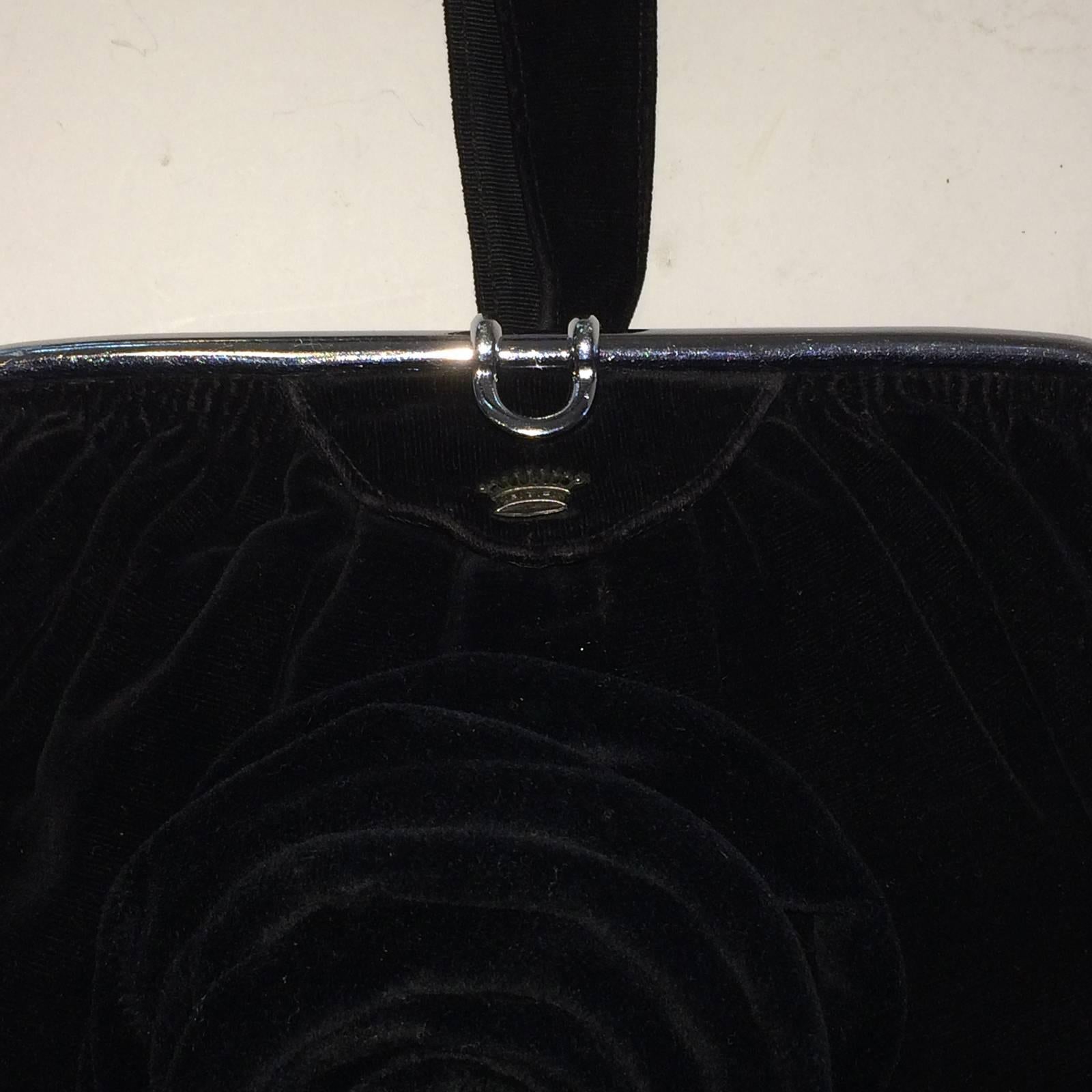 Art Deco Black Velvet Evening Bag with Rose made of Velvet to front, below Manufacturers Insignia of a Silver Metal Crown above. The Chrome Frame along top, has a rear hand grip for ease and security. The chrome has a snap, “roll-over” clasp, when