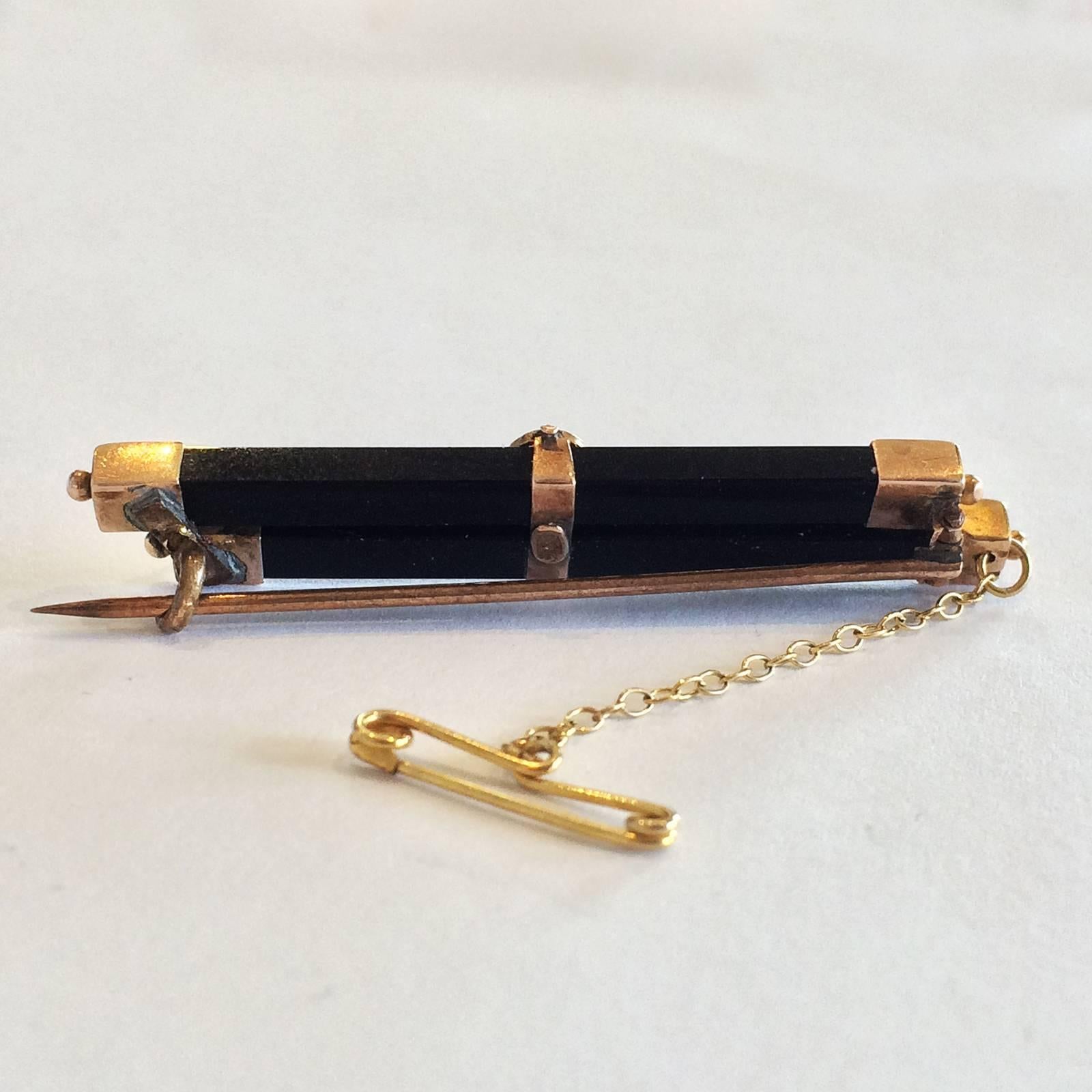Art Deco Brooch of Onyx Bars, 9ct Rose Gold with Fine decoration holding a Seed Pearl at the centre, gold caps with a gold sphere to each end of the Onyx bars. Hallmarked to the rear of the central decoration, simply “9ct”, so it is possibly of