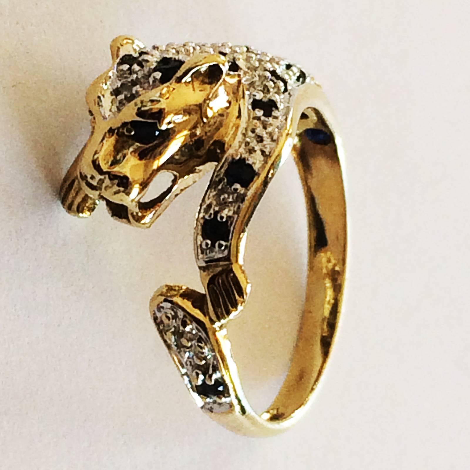 Mid Century ring in form of a spotted Leopard, 9ct Gold, 375, as Hallmarked to inner Band. Designed in a Swirl pattern with the Left Paw just touching the tail, all decorated with small Diamonds and dark blue sapphires creating the Spots. The