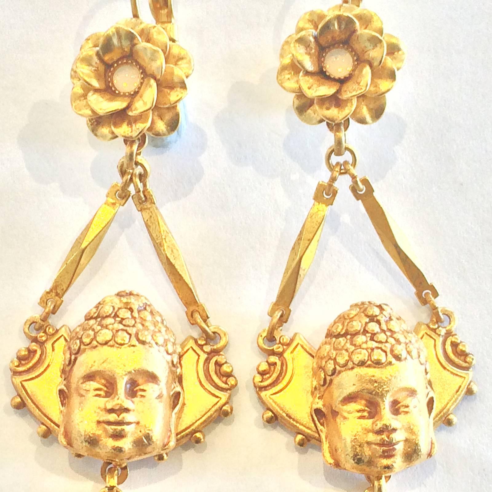 Askew of London Earrings in intense Gold finish equivalent to 18ct gold. Displaying Buddha with Flower above with Mother of Pearl centre, and a M. O. Pearl disk set to front of Asian “gold” at lower pendant. Intense 3 dimensional detail and in mint
