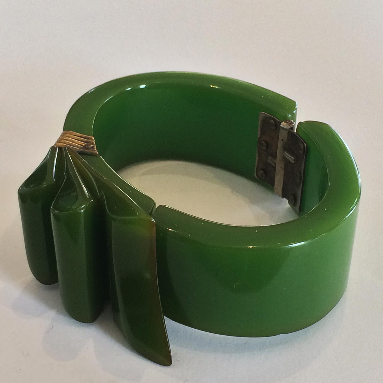 Art Deco Rare Jade Green Bakelite Clamper Bangle, hinged, in the famous Ribbon Pattern. With the reeded Bronze “Tie” around the “Ribbon” area. All in excellent condition with no damage or repairs. Soft Aged patina with a faint touch of yellow at