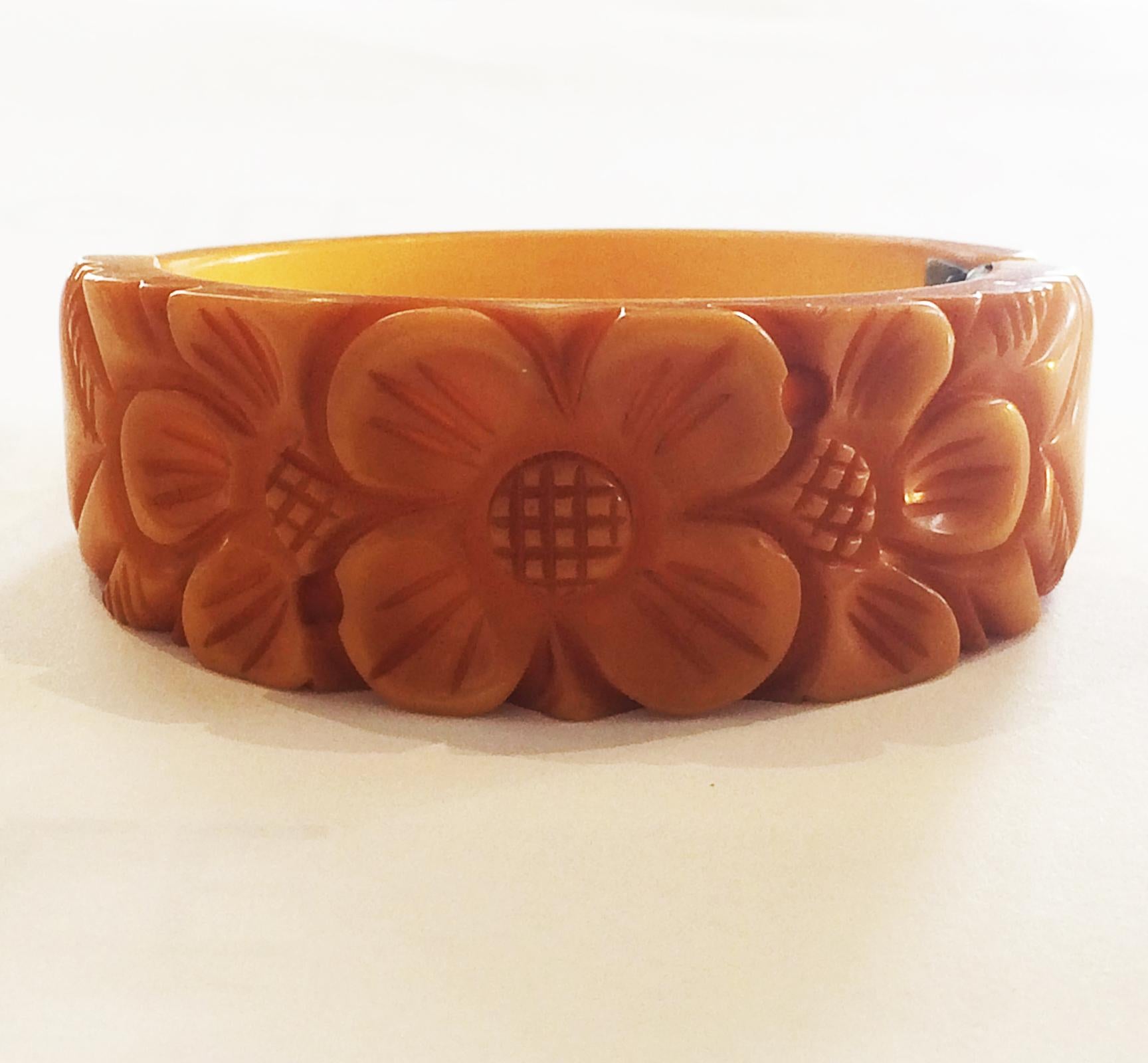 Art Deco Corn Yellow, deeply Carved Bakelite Clamper Bangle, deeply carved central Daisy, overlapping another Daisy to each side, and leaves to the outer edges. Some of the carving actually incorporates deep holes all the way through the design. All