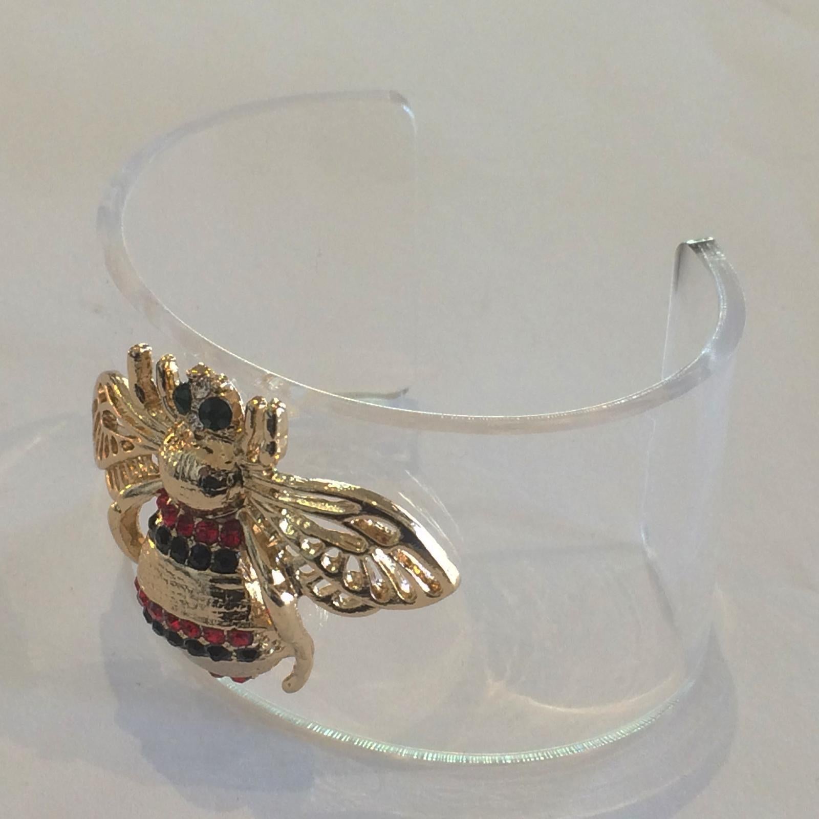 Oscar de la Renta Clear Lucite Bangle with Bumble Bee, Gilt with lines of Red and Black,  Diamantes to create the Bee stripes, and dark green eyes. Absolutely immaculate condition with no repairs or losses. Dimensions are approx.: Oval opening 61mm