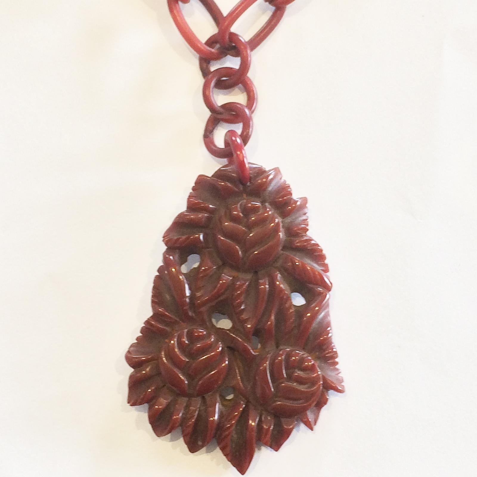 Art Deco Necklace of Deep Red, pierced and heavily carved, in Roses and Leaves Pendant, hanging on 3 links of the original, full perimeter, Deep Red Celluloid link necklace. All in perfect original condition. Extremely rare that the Chain is
