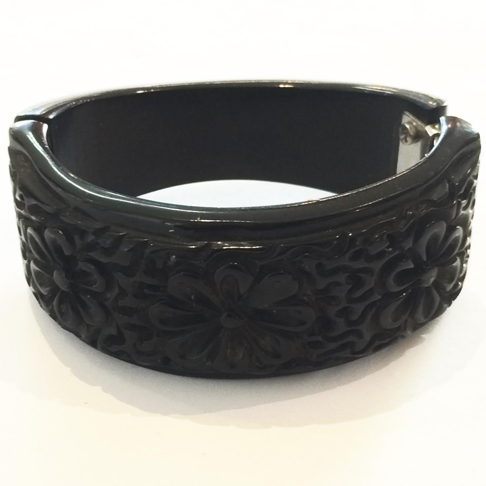 Art Deco Clamper Bangle Heavily Carved Pierced detail, in Rare Black Bakelite, with 3 daisies with random rear pattern. Original nickel plate spring hinge in perfect working condition, with no damage or repairs at all to the bangle. One of the best