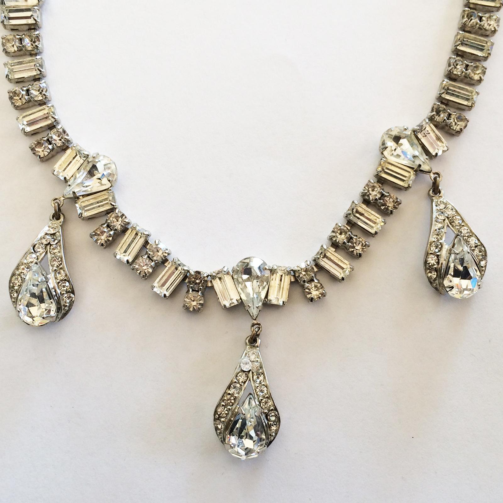 Art Deco, Fine Necklace in Rhinestones, with a Triple pendant design and adjustable clasp. Extremely well set with variations of double Rhinestones, separated by Baguette Cut stones between links; the Pendants have a perfect “Tear Drop” gem,