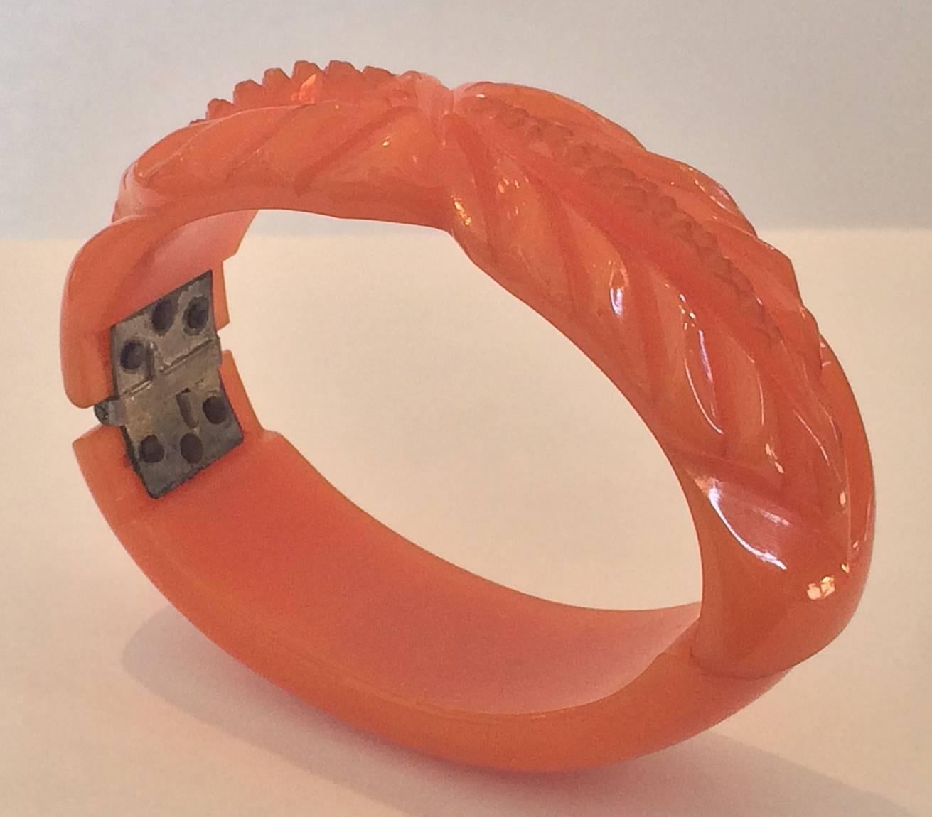Outstanding Art Deco Bangle, Clamper style in Tangerine/light Orange with flower/leaf carving. All excellent with original hinge working perfectly. No damage or repairs. Dimensions approx..: 60mm x 44mm oval opening, 12mm wide band x up to 9mm