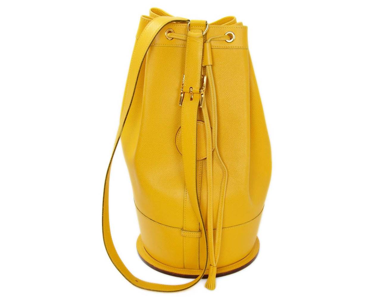 Hermes Vintage Yellow Epsom Leather Sling Bag Yellow Epsom Leather Sling Bag
This Vintage HERMES leather sling bag is made in a beautiful yellow epsom leather with goldtone hardware. Circular base with 