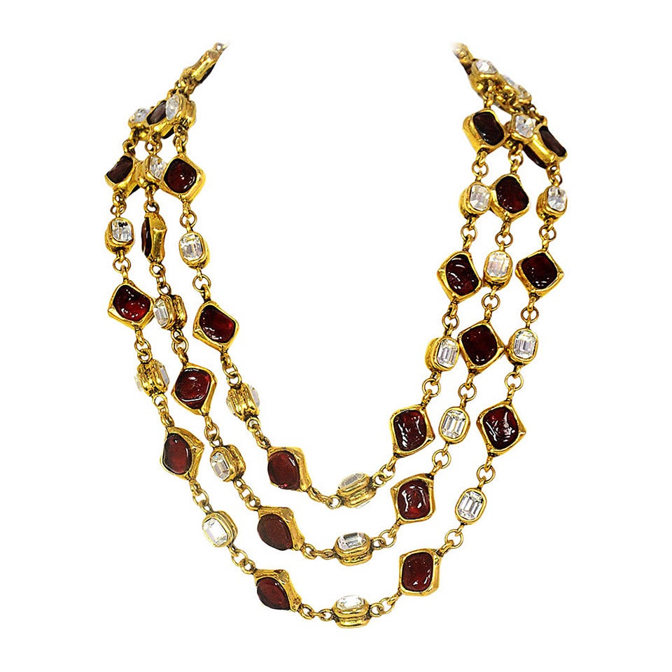 Chanel Vintage '80s Three Strand Red Gripoix & Strass Crystal Necklace
Features three strands of alternating red gripoix and strass crystals set in goldtone metal.

Made in: France
Year of Production: 1980s
Stamp: CHANEL
Closure: Hook and eye
Color: