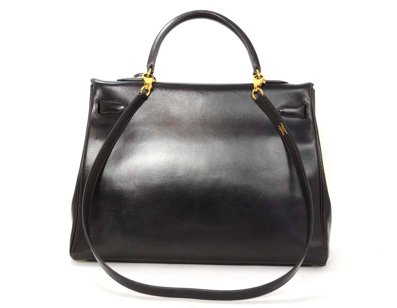 This iconic bag is finely crafted of box leather in classic black and features a sturdy reinforced leather top handle, a frontal flap, optional shoulder strap and goldtone hardware. This chic handbag is a beautiful compliment to any day or evening