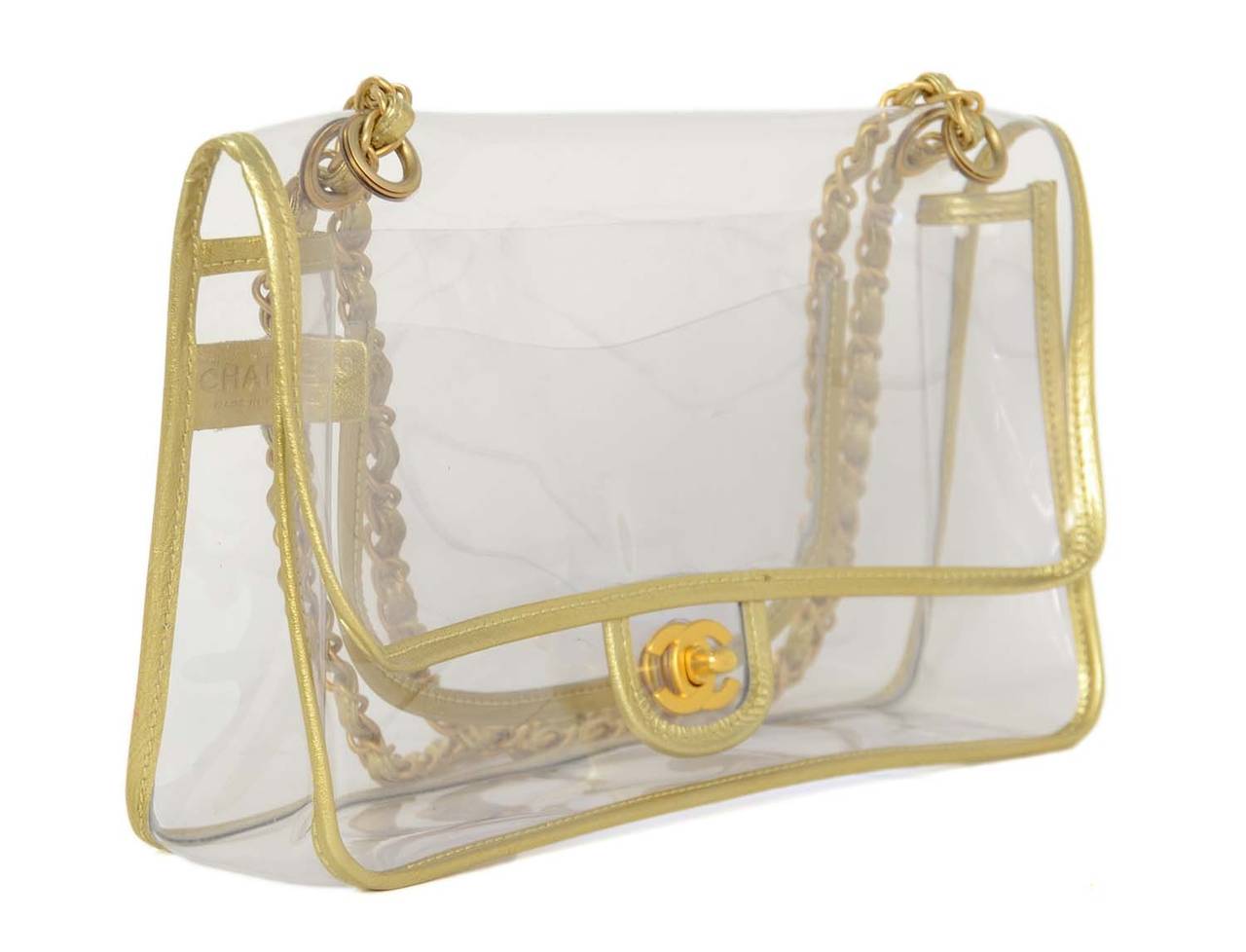 CHANEL Clear Flap Bag W/ Gold Metallic Trim & Brushed Gold Hardware c. 2007

    Made in: France
    Year of Production: 2007
    Color: Clear with gold trim
    Hardware: Brushed goldtone hardware
    Materials: Plastic with leather trim
   