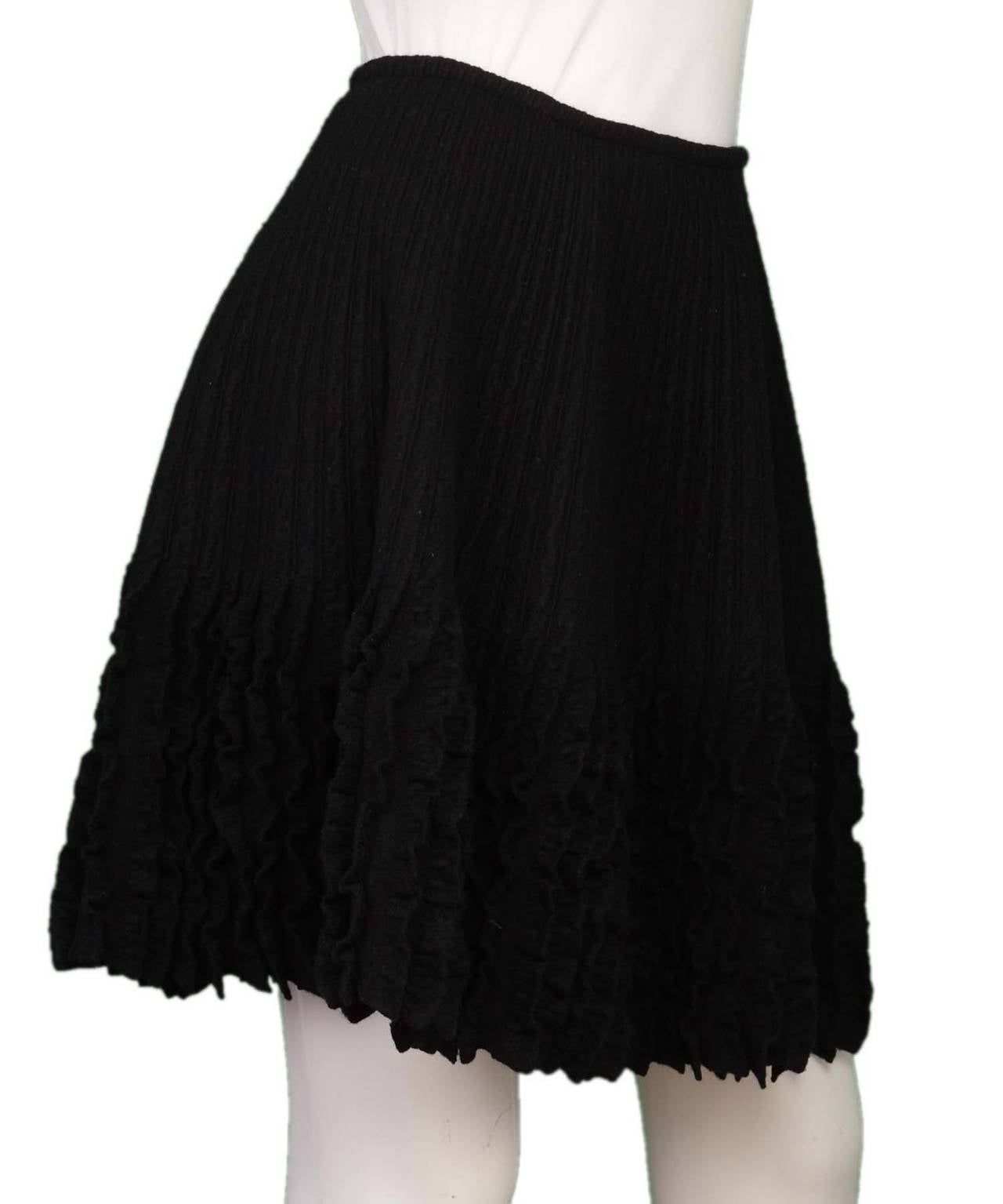 ALAIA Black Wool Flared Skirt W/ Ruffle
This skirt fits tight at the waist and then flares out.

    Made in: Italy
    Color: Black
    Composition: 77% Wool, 13% Polyester, 8% Nylon, 2% Elastodiene
    Tags: Brand and composition tags are