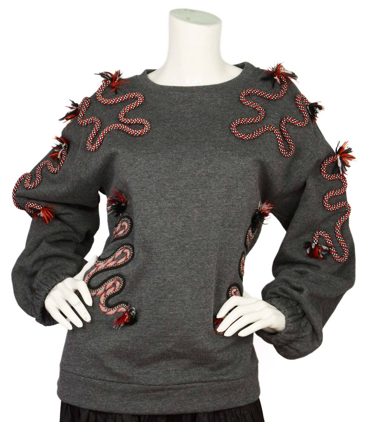 Stella McCartney Grey Sweater w/ Squiggle Red/White Rope Detailing
Features black red and white fringe at the end of rope squiggle

    Made in: Portugal
    Color: Grey with white, red, green and black trim
    Composition: 86% cotton, 14%