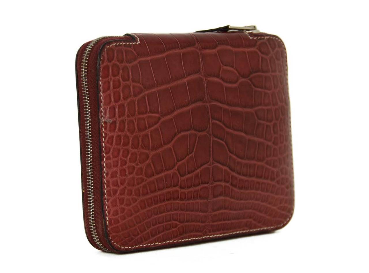 Hermes 2002 Burgundy Alligator Zip Around GM Agenda
Features three interior card holders, a palladium bar for optional notebook placement and palladium ballpoint pen

    Made in: France
    Year of Production: 2002
    Color: Burgundy
   