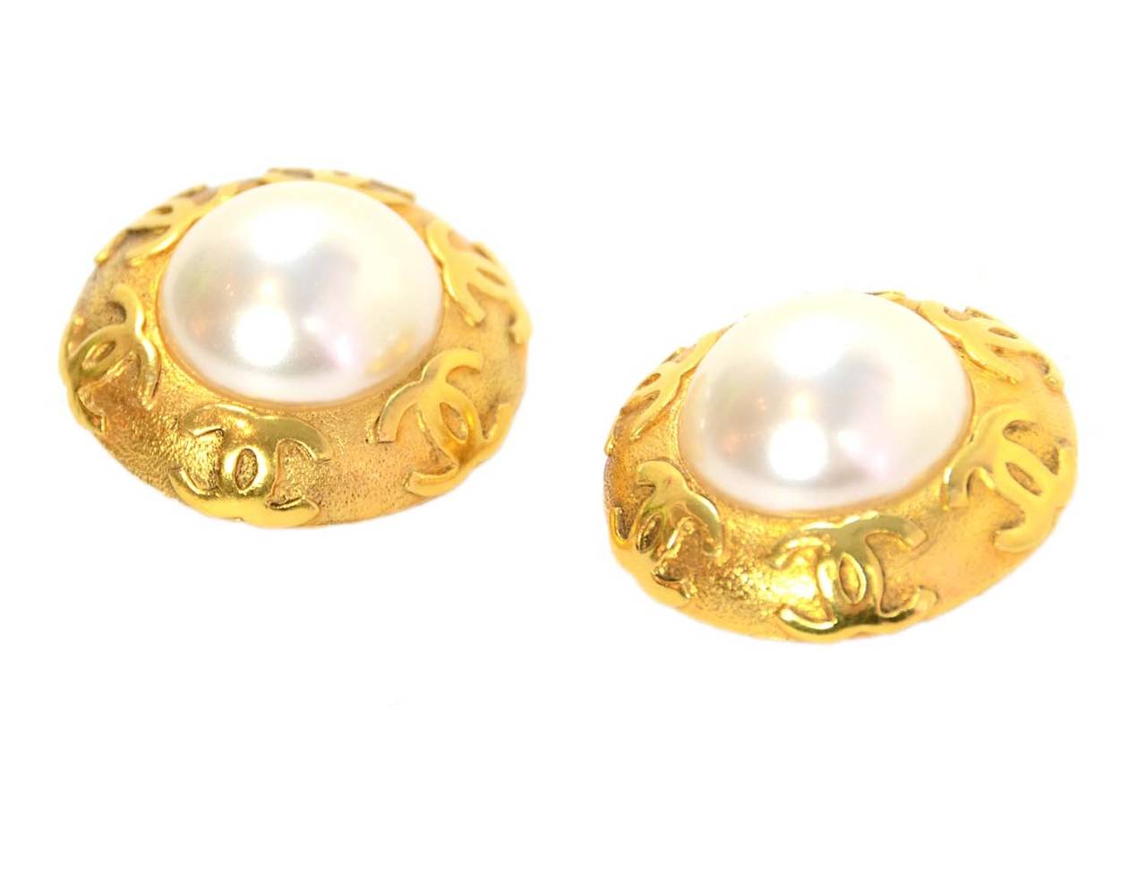 Chanel Vintage 1989 Goldtone and Faux Pearl Clip-on Earrings
Features goldtone CC's surrounding pendant

    Made in: France
    Year of Production: 1989
    Stamp: CHANEL 29 MADE IN FRANCE
    Closure: Clip-on
    Color: Goldtone
   