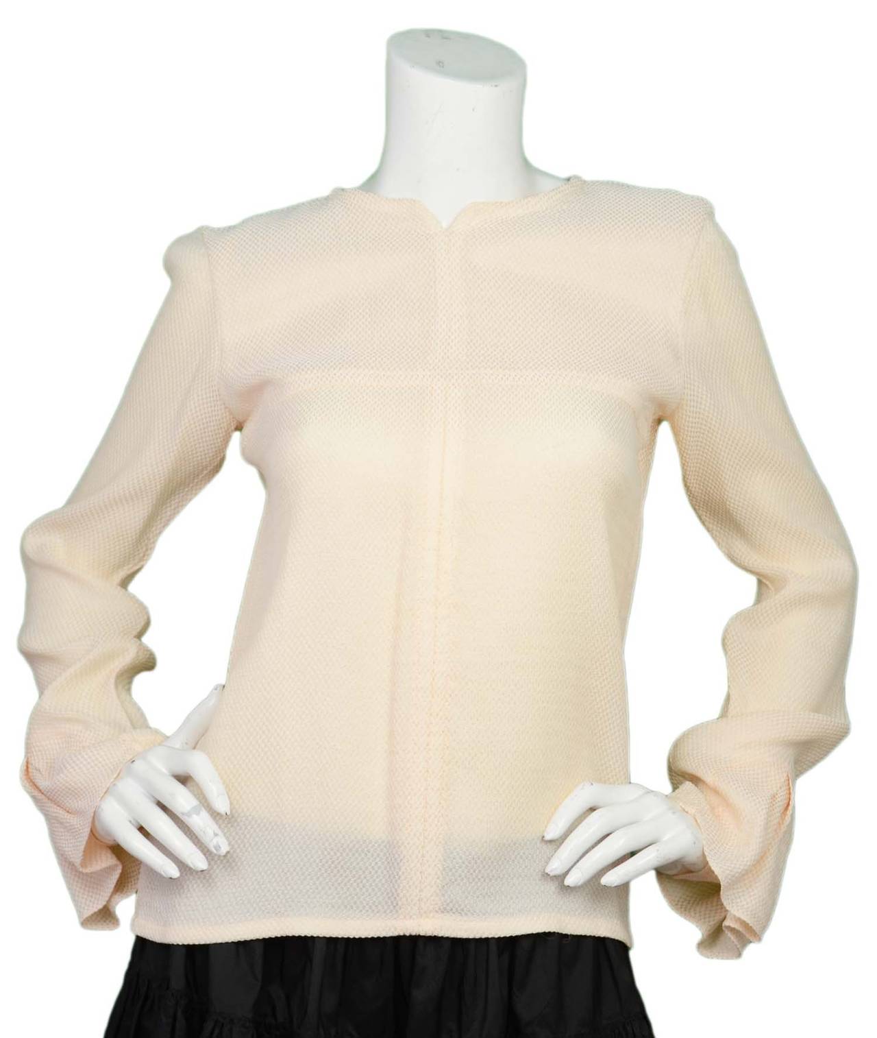 Chanel Cream Waffle-Print Blouse w/Pleated Sleeve Detailing sz 38
Features slit in back with faux pearl button loop closure and inverted pleat sleeve detailing

    Made in: Italy
    Color: Cream
    Composition: 56% rayon, 44% silk
   