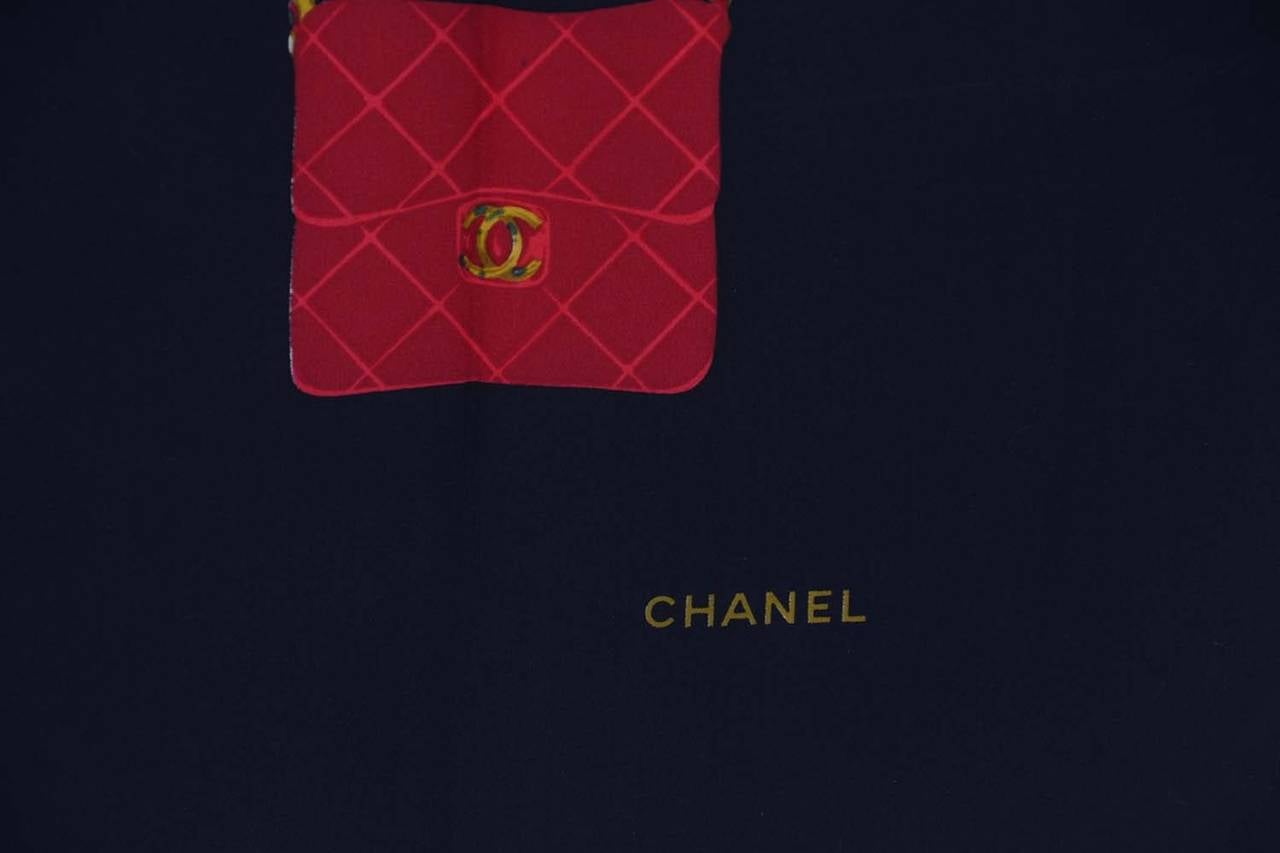 Chanel Black Silk Scarf w/Blue Red and Green Chanel Classic Bags
Features intricate stitching around the edges

    Made in: France
    Color: Black, blue, red, green and gold
    Composition: No composition tag included- believed to be 100%