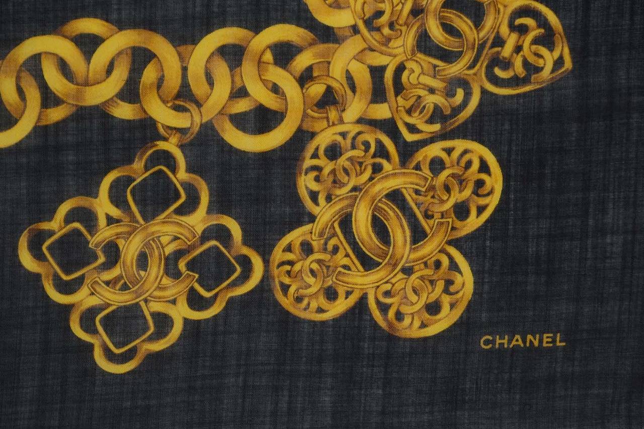 Chanel Black and Gold Cashmere and Silk Scarf w/CC Chain Border
Features frayed edge detailing

    Made in: Italy
    Color: Black and gold
    Composition: 52% Silk, 48% Cashmere
    Overall Condition: Excellent with the exception of very