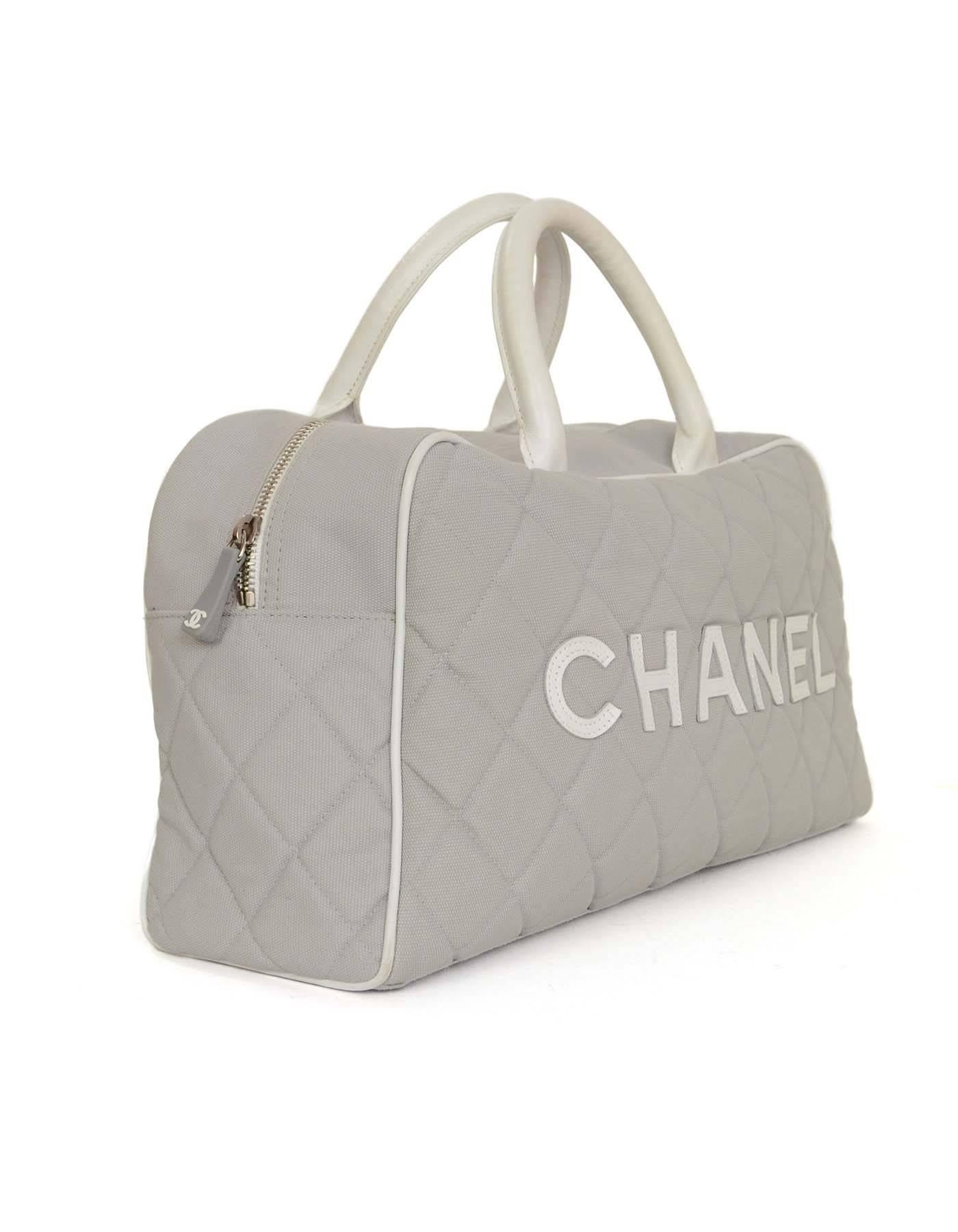 Chanel Grey Quilted Canvas Bowler Bag
Features white leather piping and leather CHANEL letters stitched across the front. Large zippered pocket on rear and protective footed bottom.  

Made in: Italy
Year of Production: 2000-2002
Color: Grey