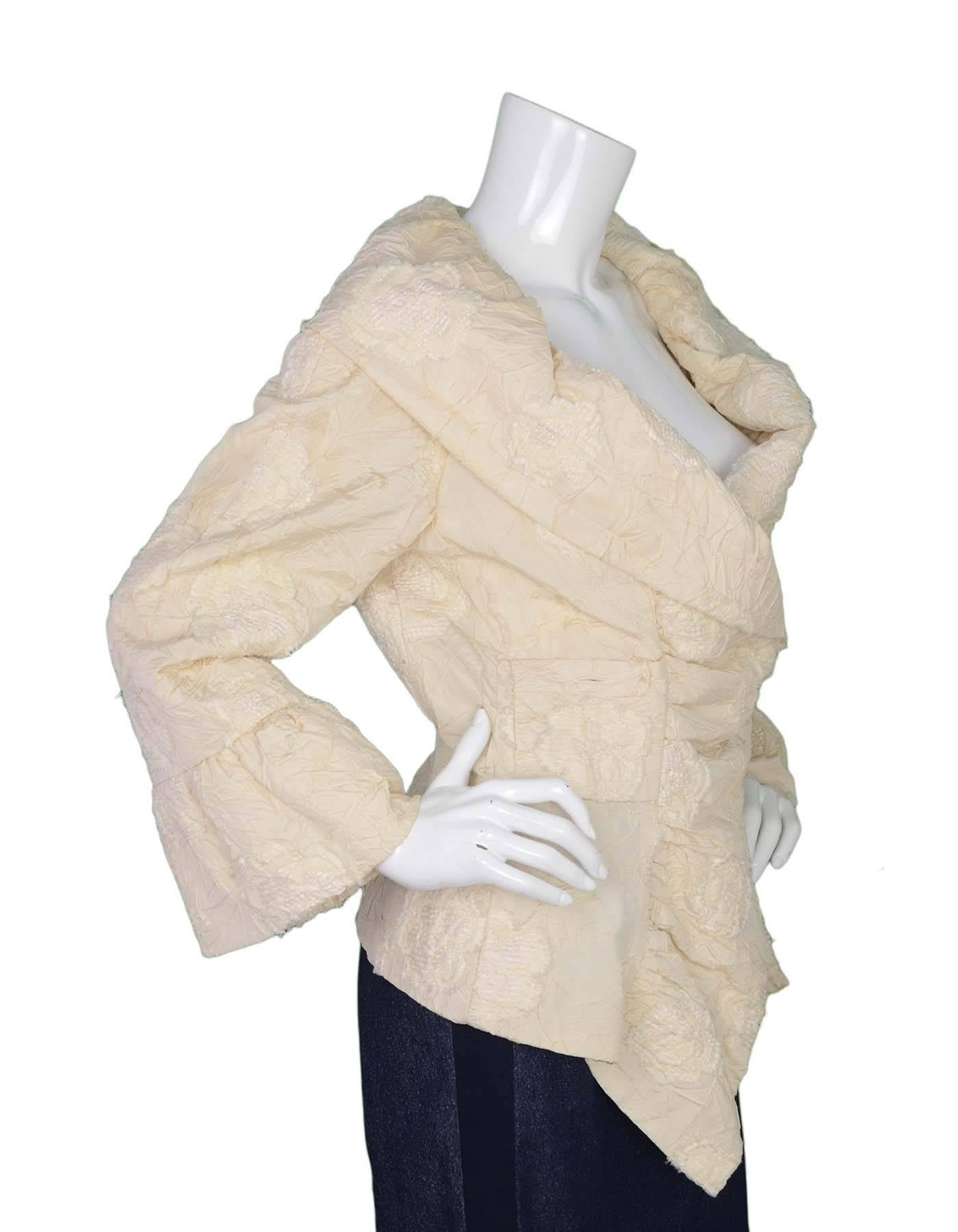 Chanel Textured Silk Jacket 
Features floral textured design throughout jacket as well as a shawl style collar and asymmetrical hemline
Made In: France
Year of Production: 2006
Color: Ivory
Composition: 60% silk, 20% polyester, 15% nylon, 5%