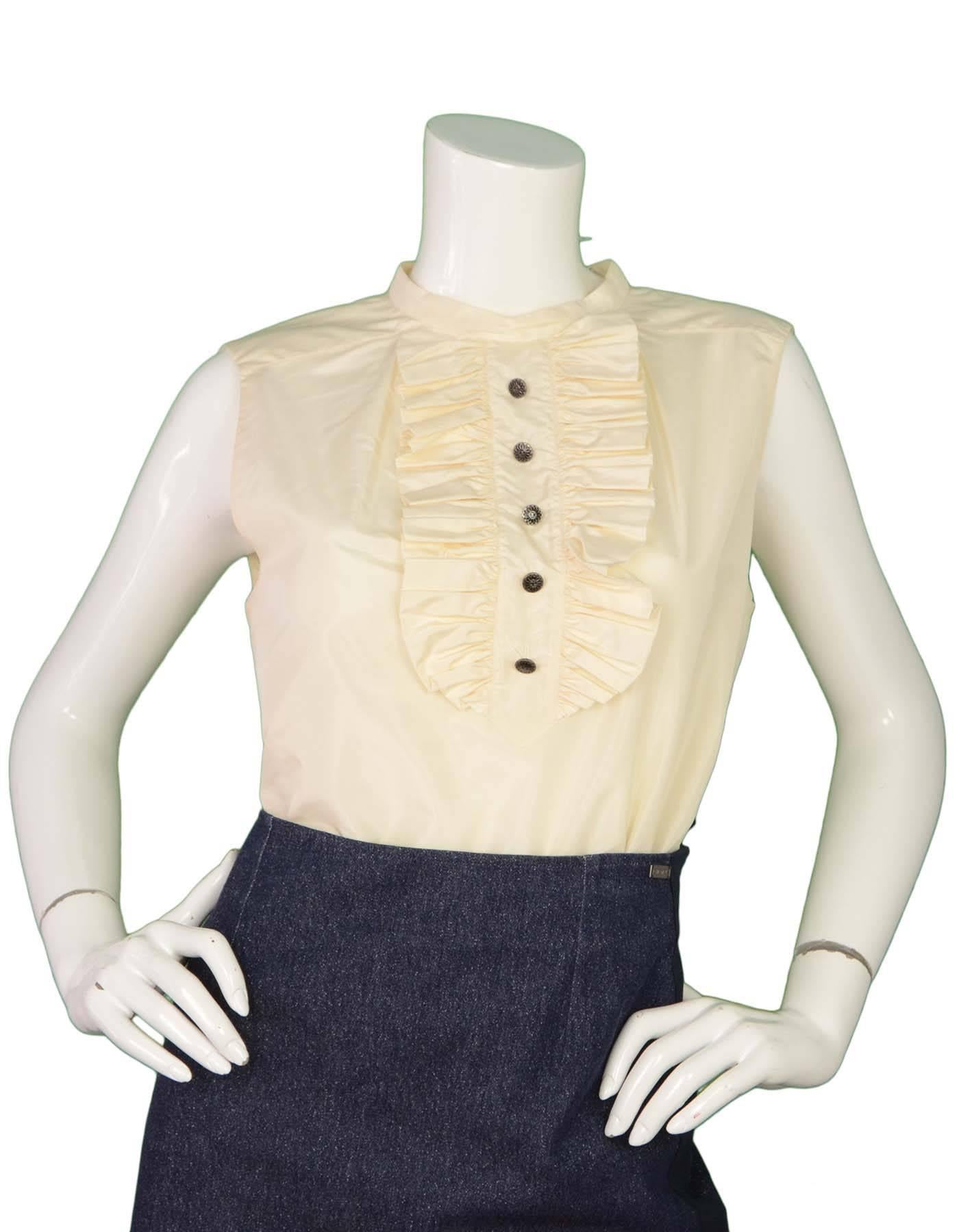 Chanel Silk Sleeveless Top 
Features ruffles at center bust with decorative buttons
Made In: France
Year of Production: 2006
Color: Ivory
Composition: 100% silk
Lining: None
Closure/opening: Back center hidden button down closure
Exterior