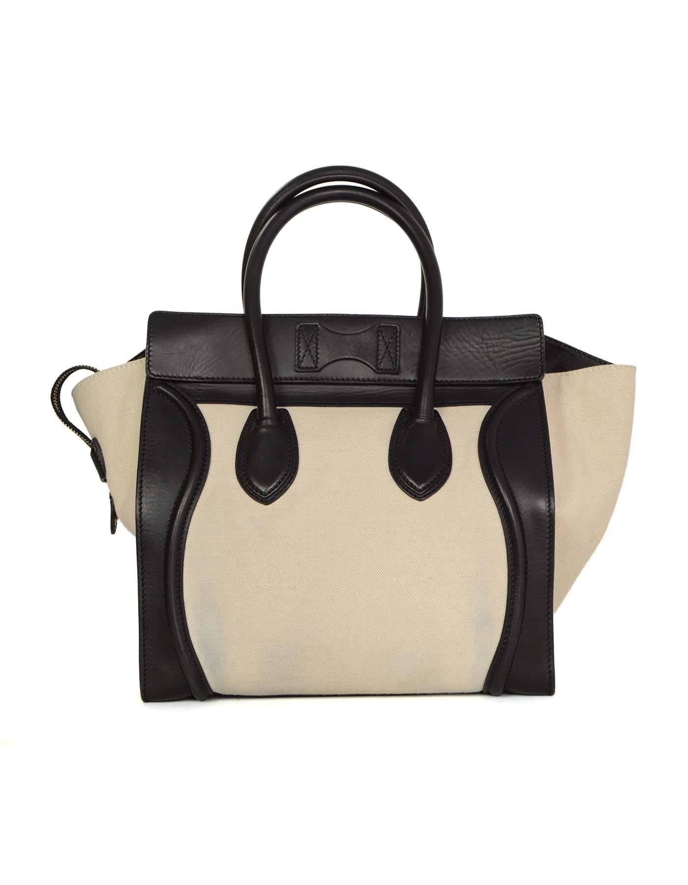 Celine Ivory & Black Mini Luggage Tote 
Features dual rolled handles and Celine logo
Made In: Italy
Color: Black
Hardware: Goldtone
Materials: Leather and canvas 
Lining: Black leather
Closure/Opening: Zip across top
Exterior Pockets: One