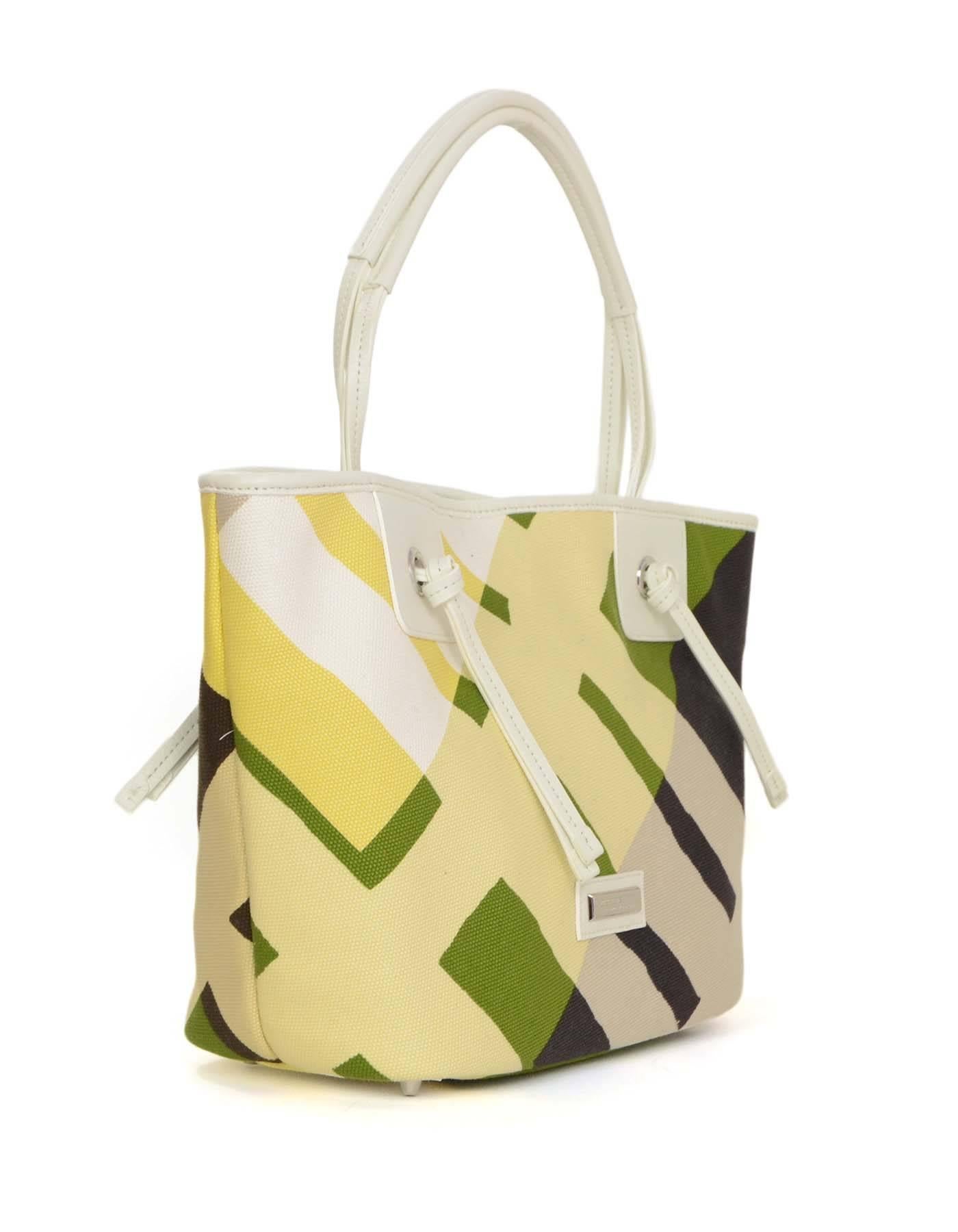 Burberry New Printed Canvas Tote Bag
Features multi-colored graphic print with Burberry logo hardware

Color: White, yellow, beige, purple and green
Hardware: Silvertone
Materials: Canvas and leather
Lining: None
Closure/opening: Open top