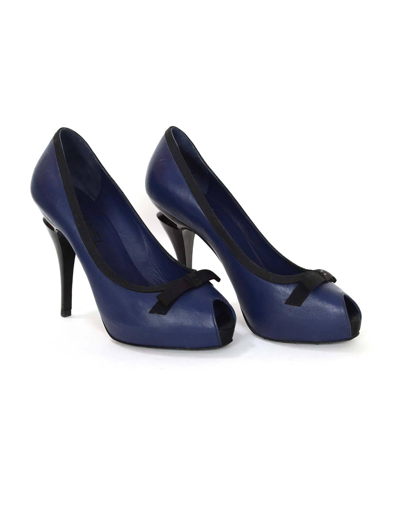 Chanel Navy & Black Peep Toe Pumps sz 36.5
Features Chanel CC charm on bow with black grosgrain trim detailing

Made in: Italy
Color: Navy and black
Composition: Leather and grosgrain
Sole Stamp: CC Made in Italy 36 1/2 C
Closure/opening: