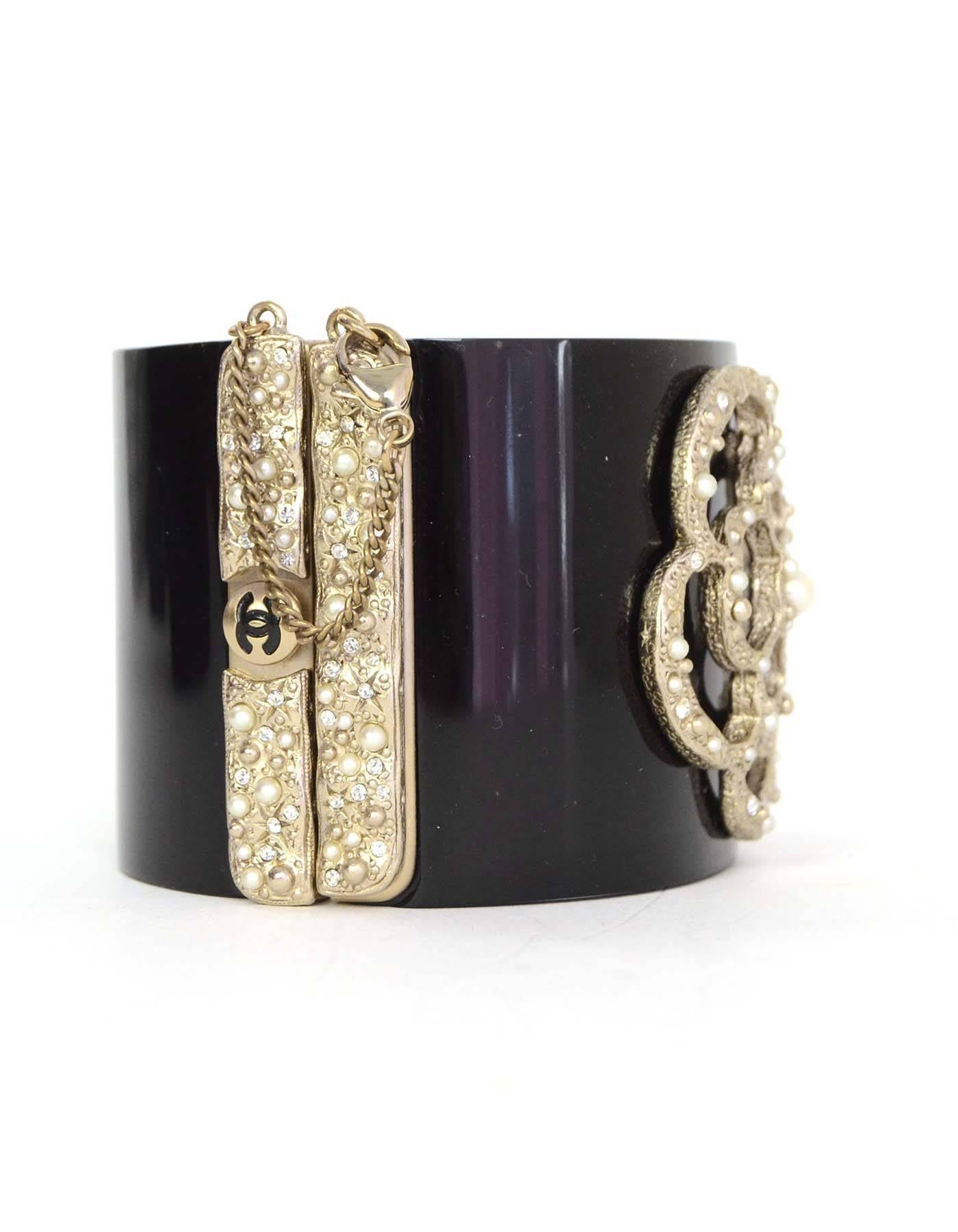 Chanel Black Resin & Textured Gold Camelia Cuff
Features pearl and crystal detailing throughout hardware and camelia flower
Made In: France
Year of Production: 2013
Color: Black, pale gold, and ivory
Materials: Resin, metal, faux pearl and