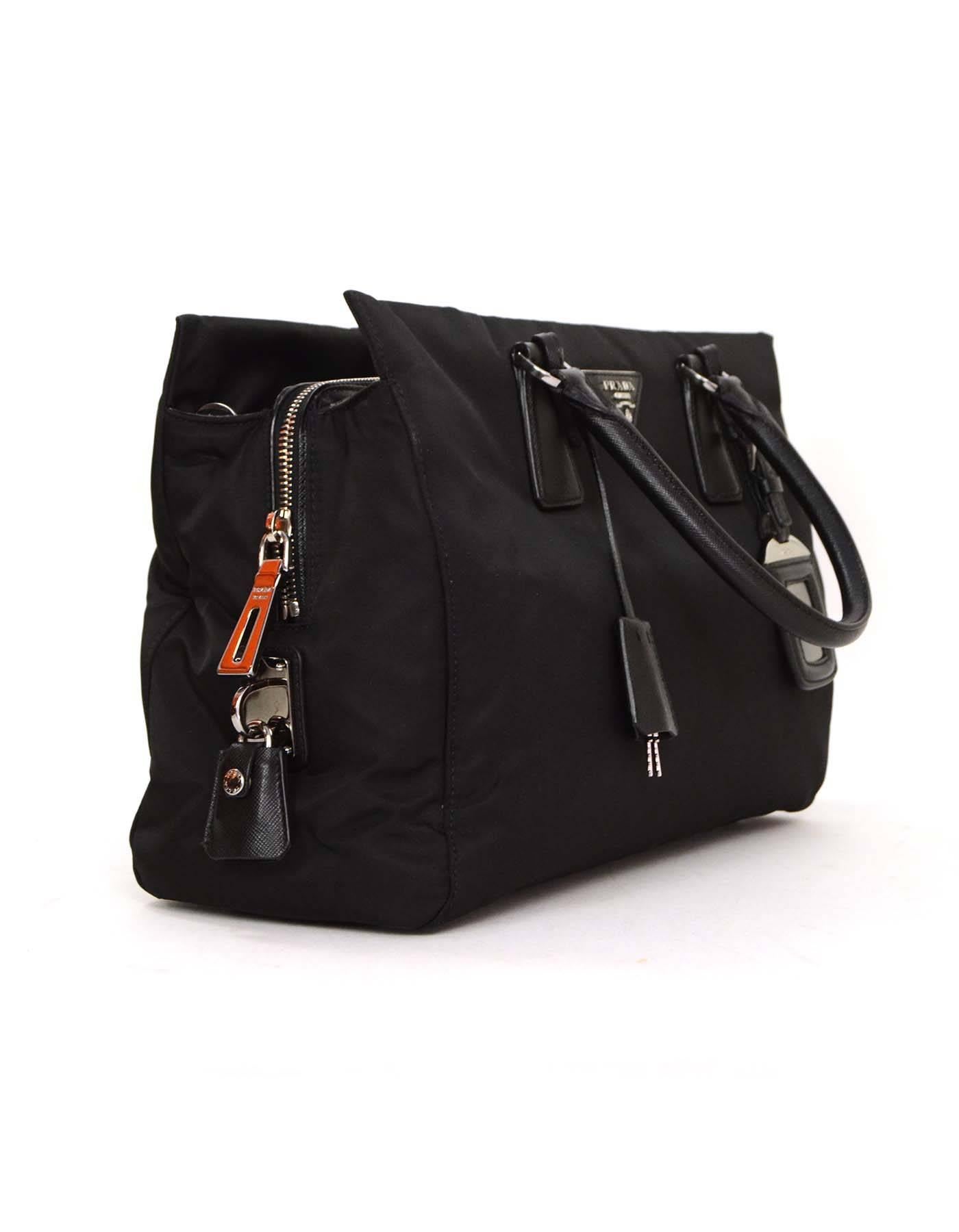 Prada Black Nylon Tote Crossbody Bag
Features Prada logo with detachable strap, clochette/ lock and luggage tag

Made In: Italy
Color: Black
Hardware: Silvertone
Materials: Nylon with leather trim
Lining: Black logo textile
Closure/Opening: