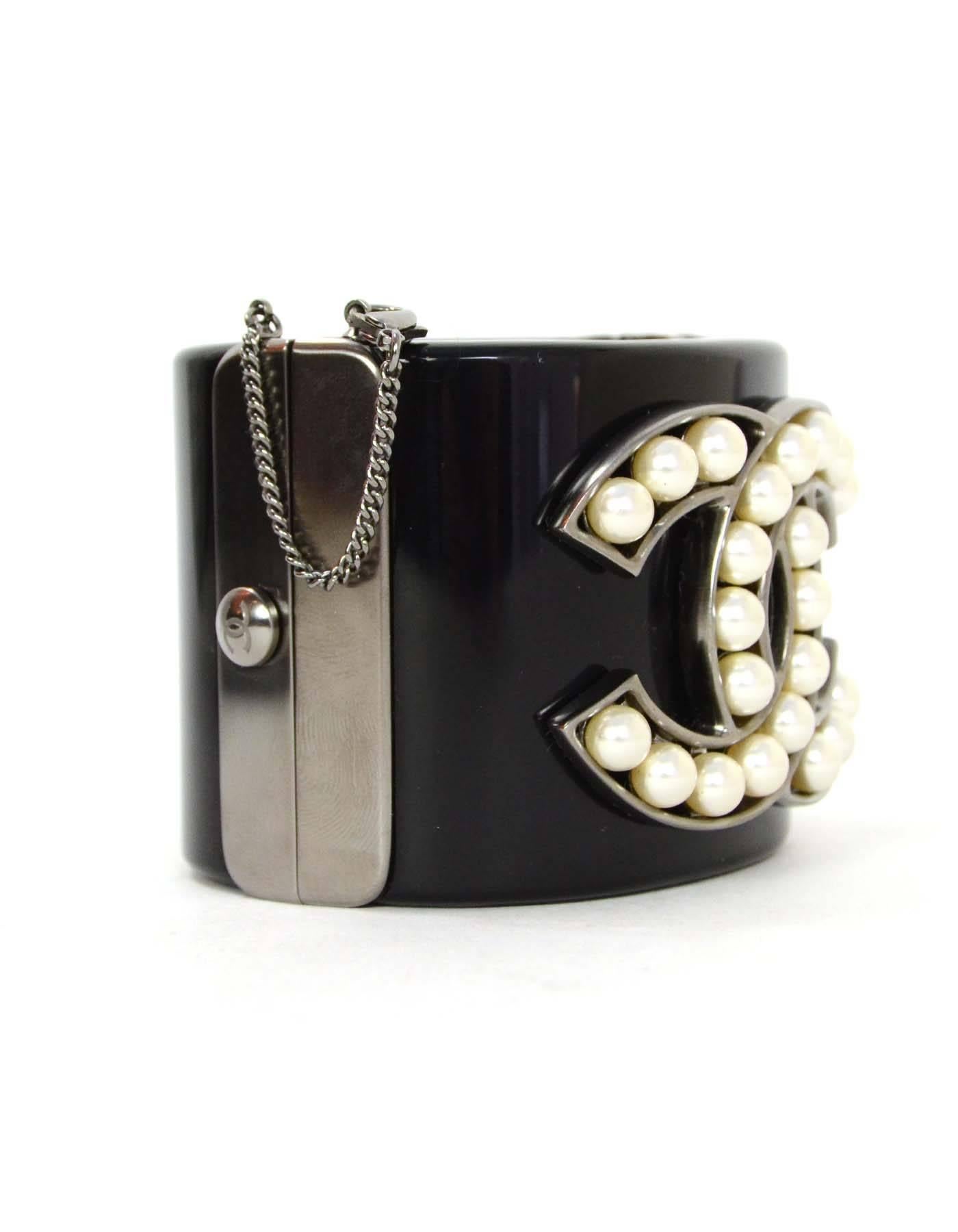 Chanel Pearl & Black Resin CC Cuff
Features faux pearls in shape of large CC pendant on cuff
Made In: Italy
Year of Production: 2014
Color: Black, ivory, ruthenium
Materials: Resin, metal, and faux pearl
Closure: Push lock with lobster claw