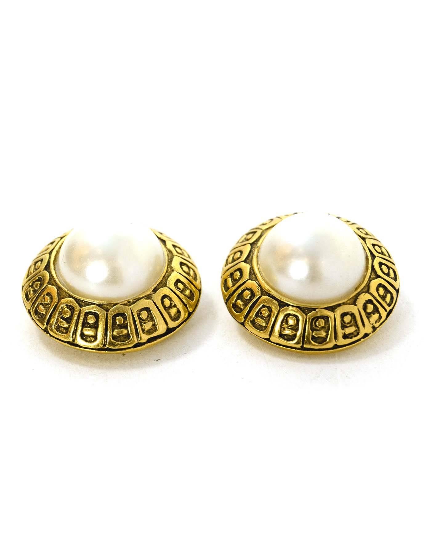 Chanel Gold & Pearl Clip On Earrings 
Features carved design in goldtone metal framing pearl
Made In: France
Year of Production: 1990-1992
Color: Goldtone and ivory
Materials: Faux pearl and metal
Closure: Clip on
Stamp: Chanel CC Made in