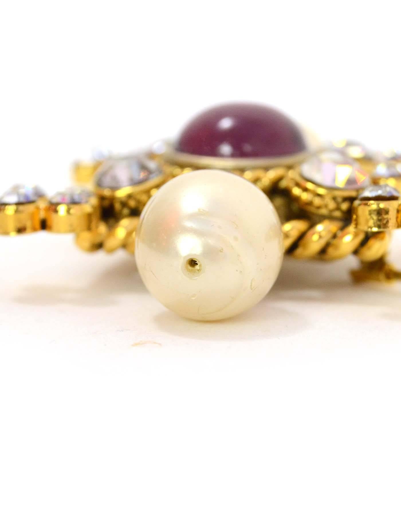 Chanel Crystal & Pearl Brooch
Features twisted gold metal framing brooch with purple stone in center
Color: Goldtone, ivory and purple
Materials: Metal, crystal, faux pearl and stone
Closure: Pin back closure
Overall Condition: Excellent