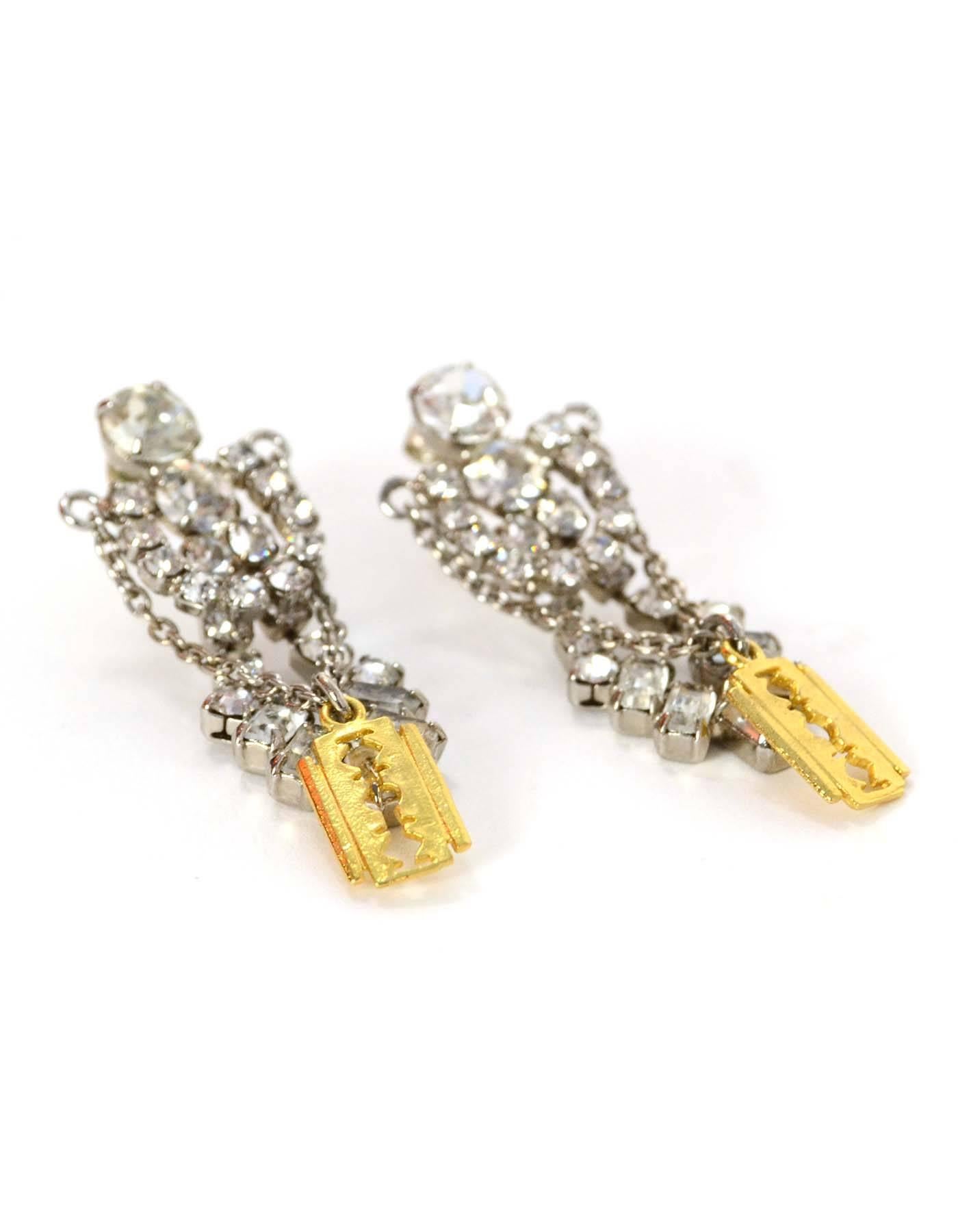 Tom Binns Crystal & Gold Razor Chandelier Earrings
Features crystal drop design with goldtone razor hanging in front
Made In: U.S.A
Color: Goldtone and silvertone
Materials: Metal and crystal
Closure: Pierced back closure
Overall Condition:
