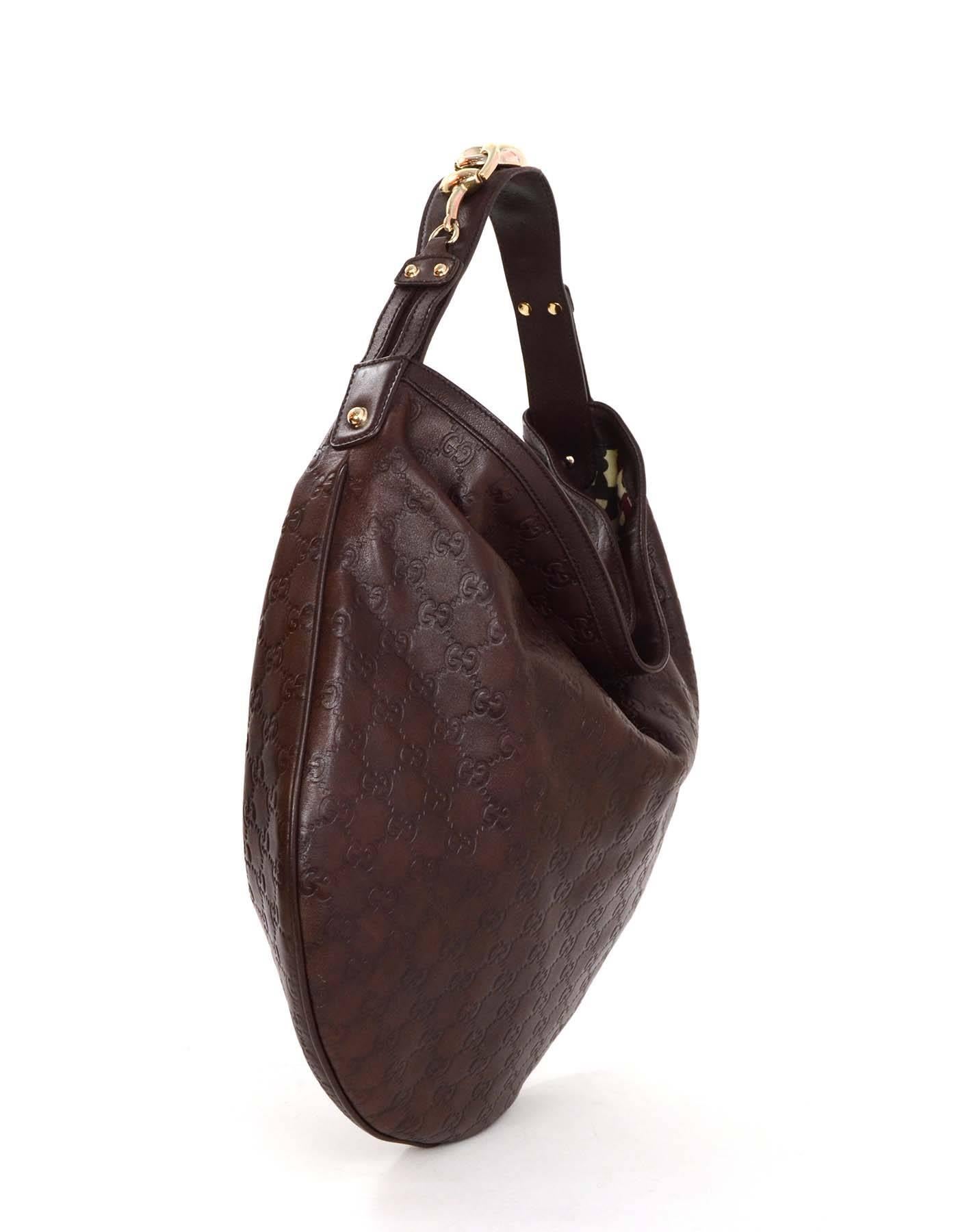 Gucci Brown Monogram Leather Hobo Bag 
Features horsebit hardware on shoulder strap
Made In: Italy
Color: Brown
Hardware: Goldtone
Materials: Leather
Lining: Printed canvas
Closure/Opening: Open top
Exterior Pockets: None
Interior Pockets: